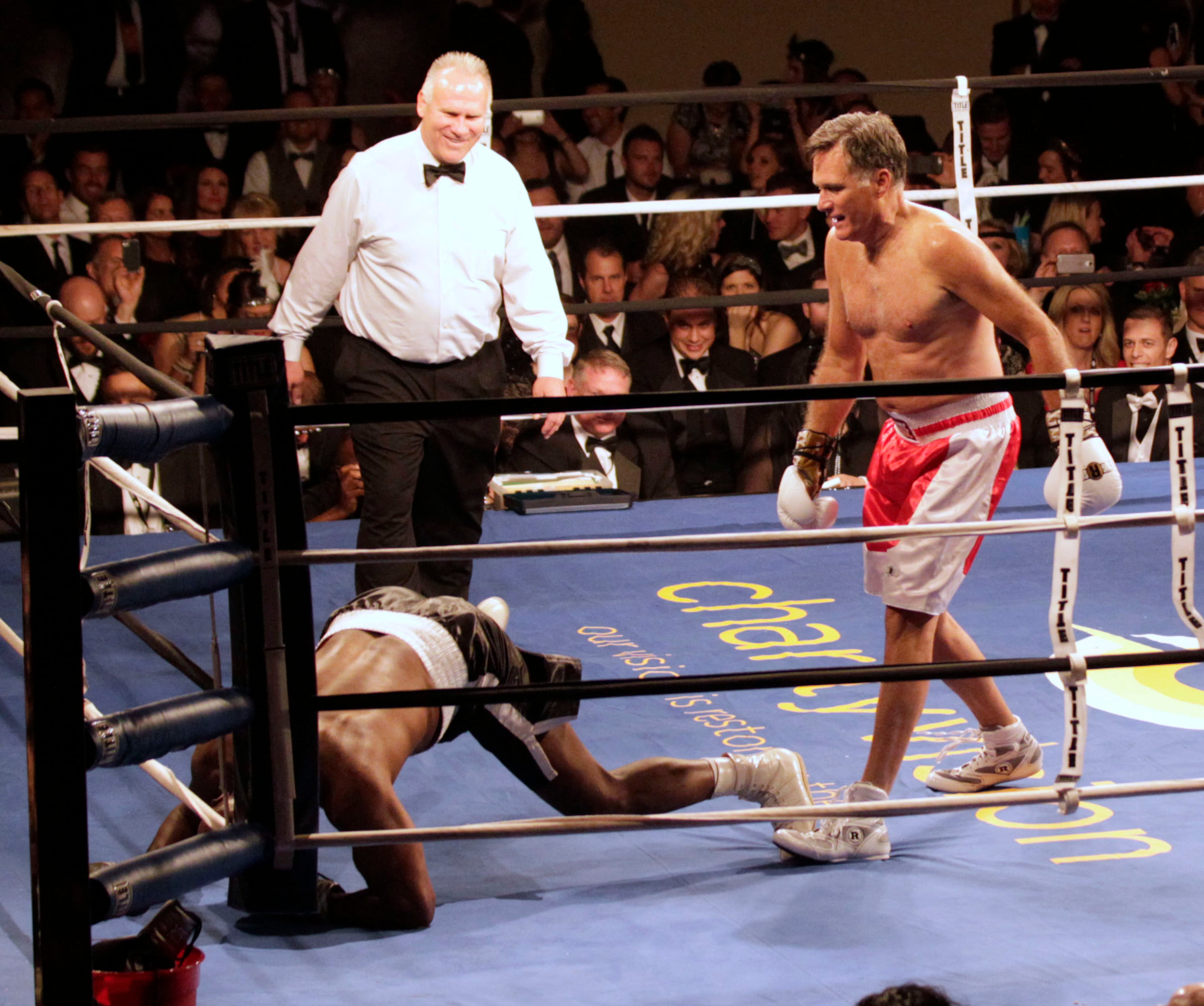 SALT LAKE CITY, UT - MAY 15: Mitt Romney, (R) watches after he knocked down Evander Holyfield (L), during a fight in a charity boxing event on May 15, 2015 in Salt Lake City, Utah. The event was held to raise money for "Charity Vision" a charity that aims to restore sight to the blind and visually impaired. (Photo by George Frey/Getty Images)