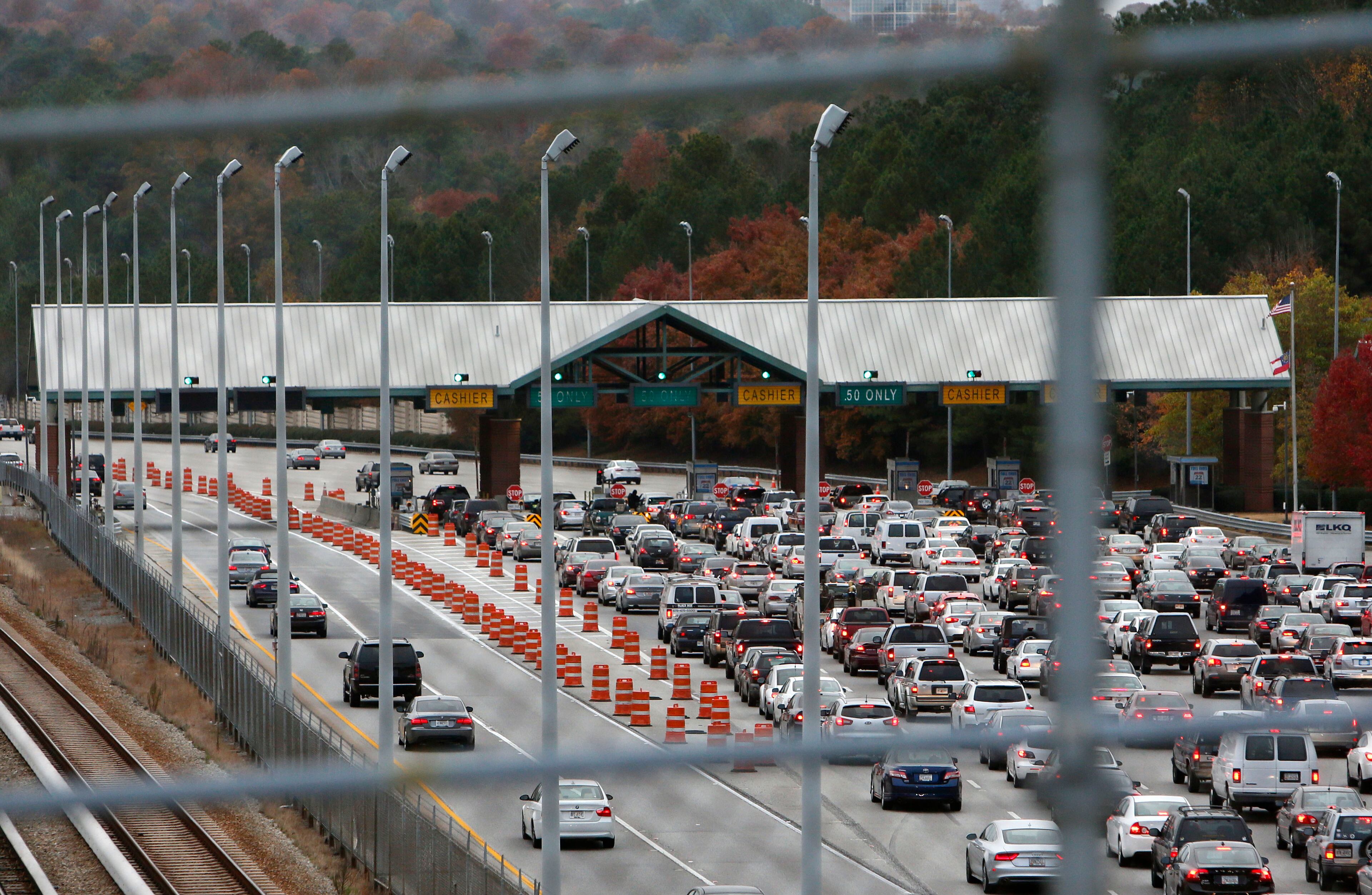 The toll booth signs have been taken down, and soon the toll booths will be gone. Morning commute traffic on GA 400 in the toll booth area. GA 400 tolls will end Nov. 22. BOB ANDRES / BANDRES@AJC.COM