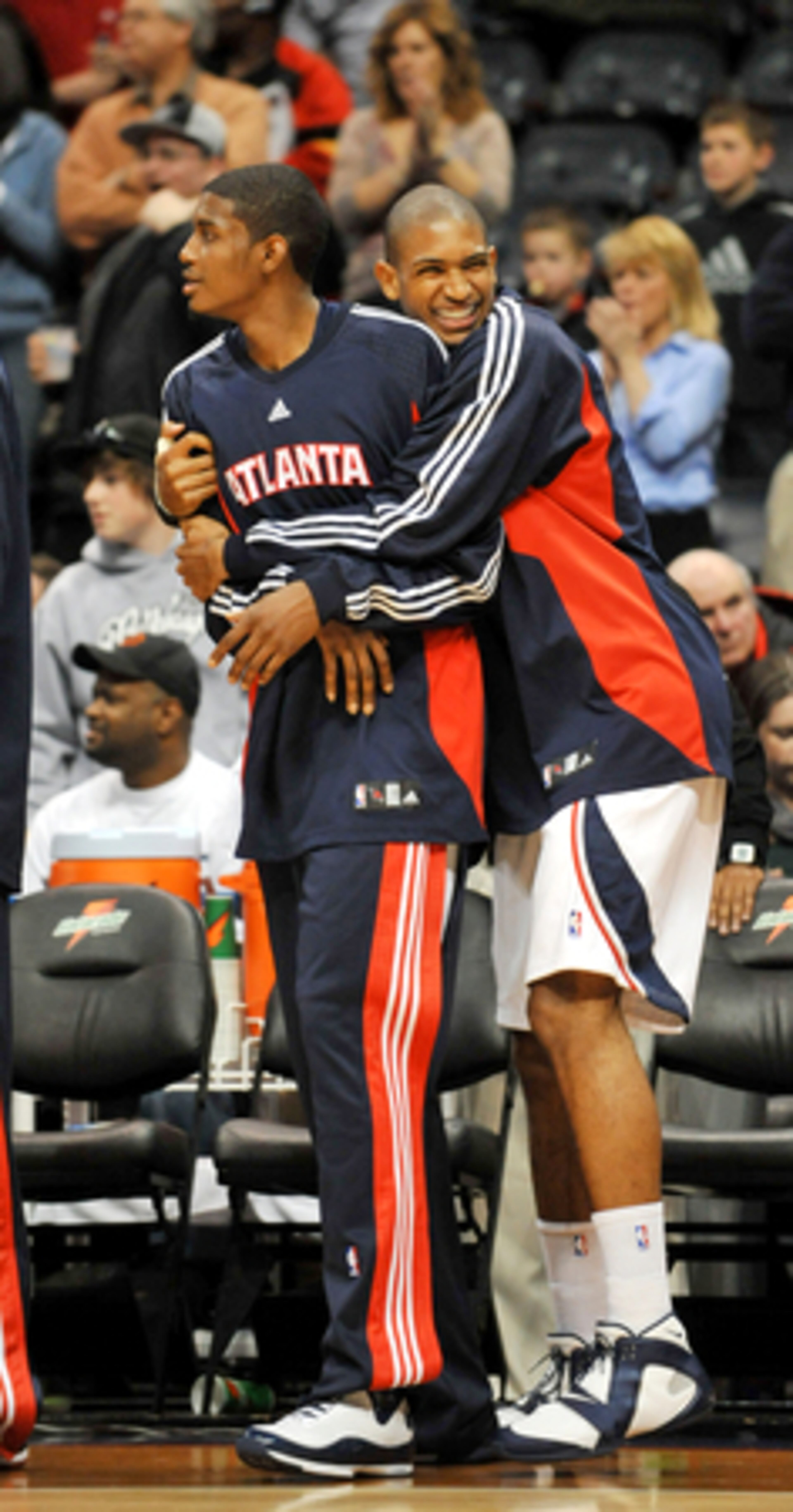 The Hawks' Al Horford (right) gives teammate Solomon Jones a playful hug after a Miami turnover. The teams got a 15-minute break after the replay game, then returned to the court for their regularly scheduled game.