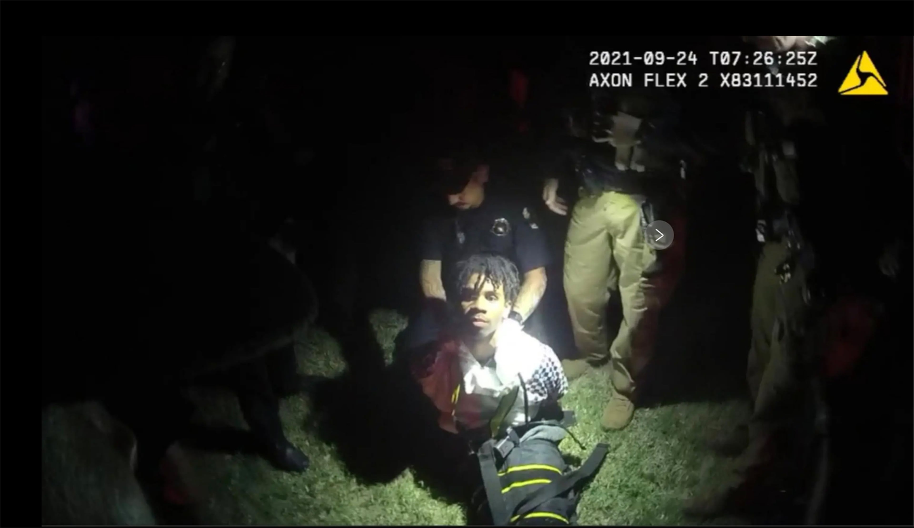 In this image from body camera video provided by Sedgwick County, Kan., police put Cedric "C.J." Lofton, 17, into a body-length restraining device called a WRAP outside his home is Wichita, Kan., on Sept. 24, 2021. Community outrage over the teenager's death prompted the Wichita Police Department to change its restraint practices. (Sedgwick County via AP)