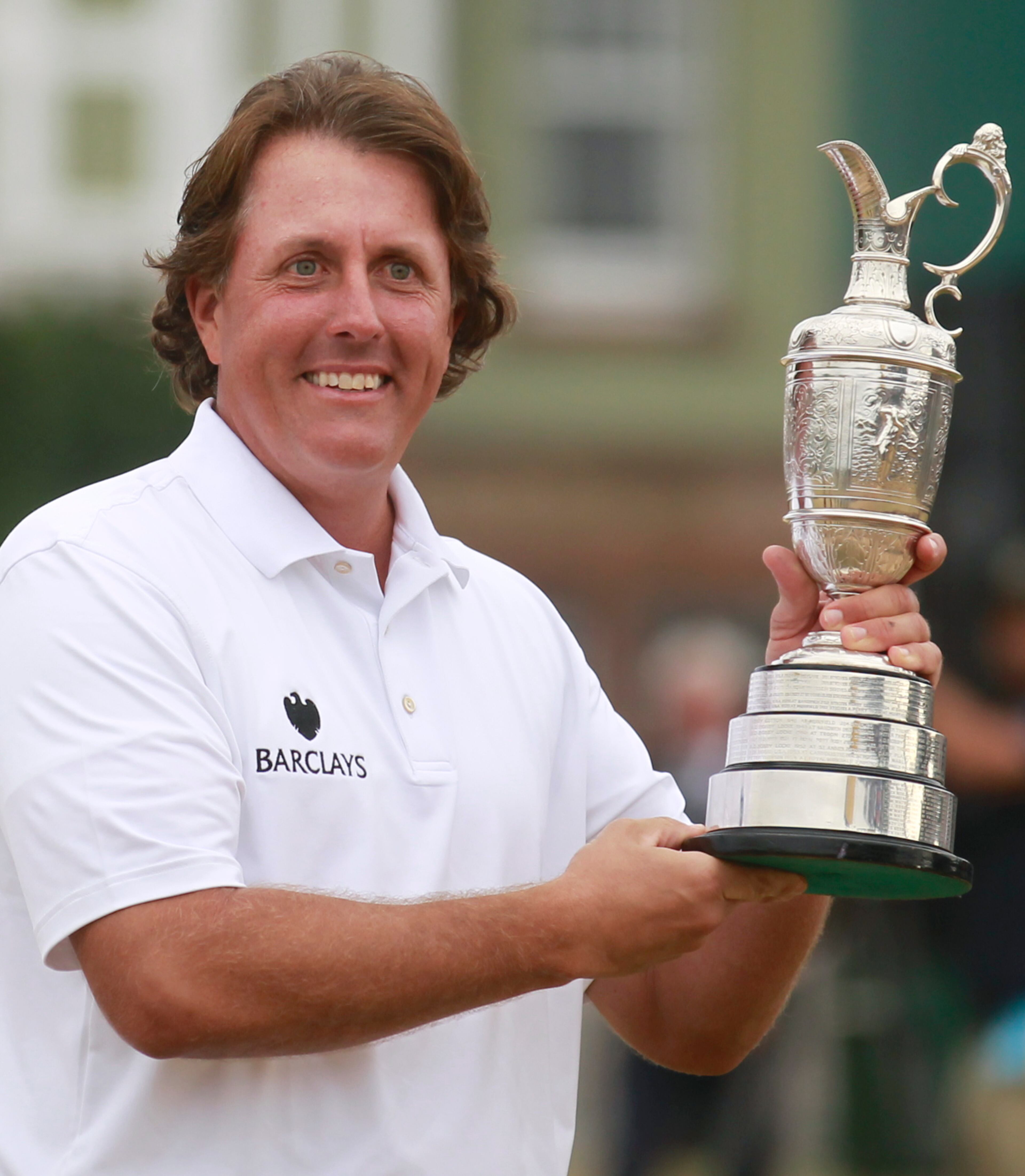 Phil Mickelson holds up the Claret Jug trophy after winning the British Open Golf Championship on Sunday, July 21, 2013.