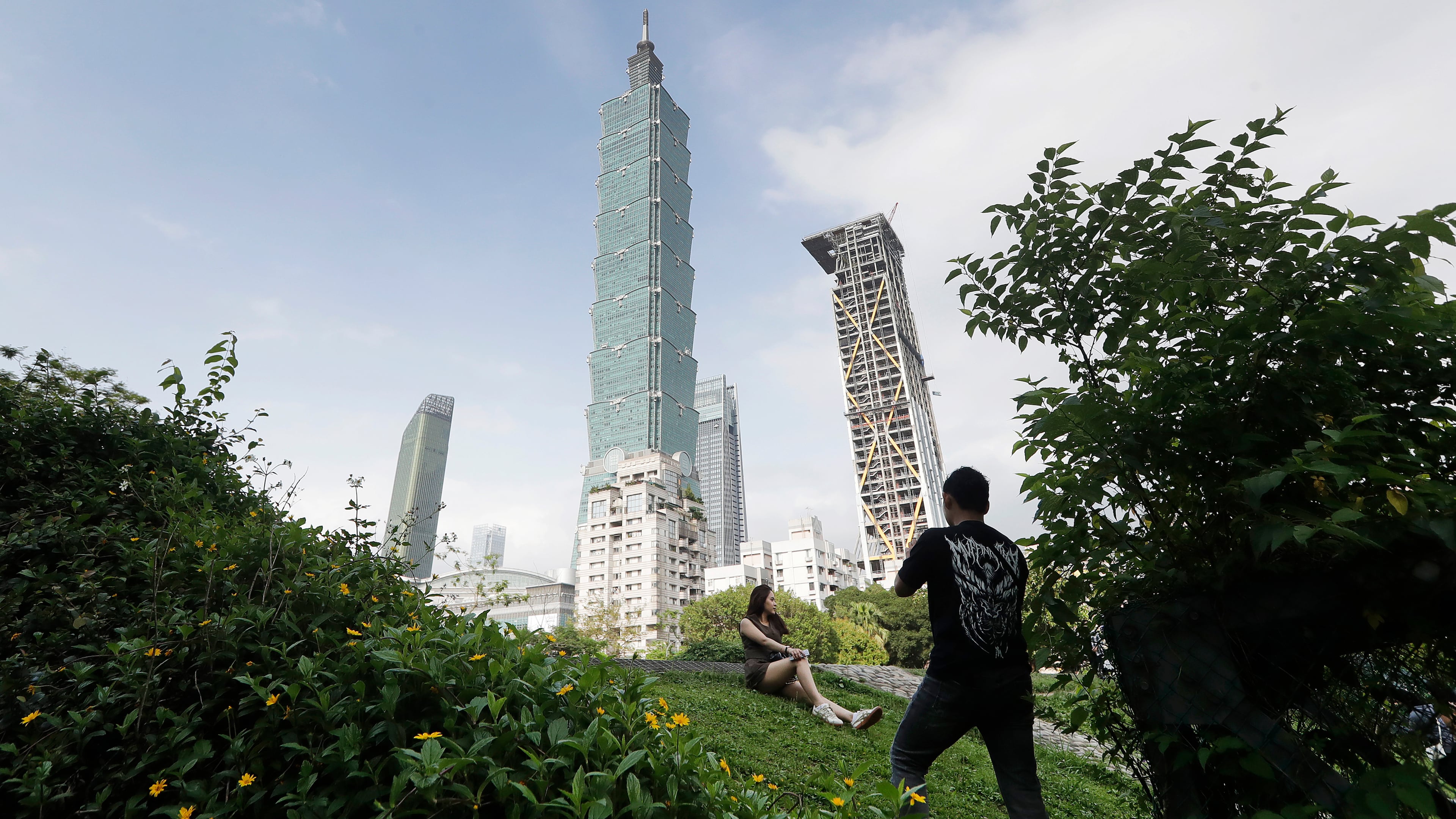 FILE - People take photos with the iconic Taipei 101 skyscraper in the background in Taipei, Taiwan, April 27, 2025. (AP Photo/Chiang Ying-ying, File)