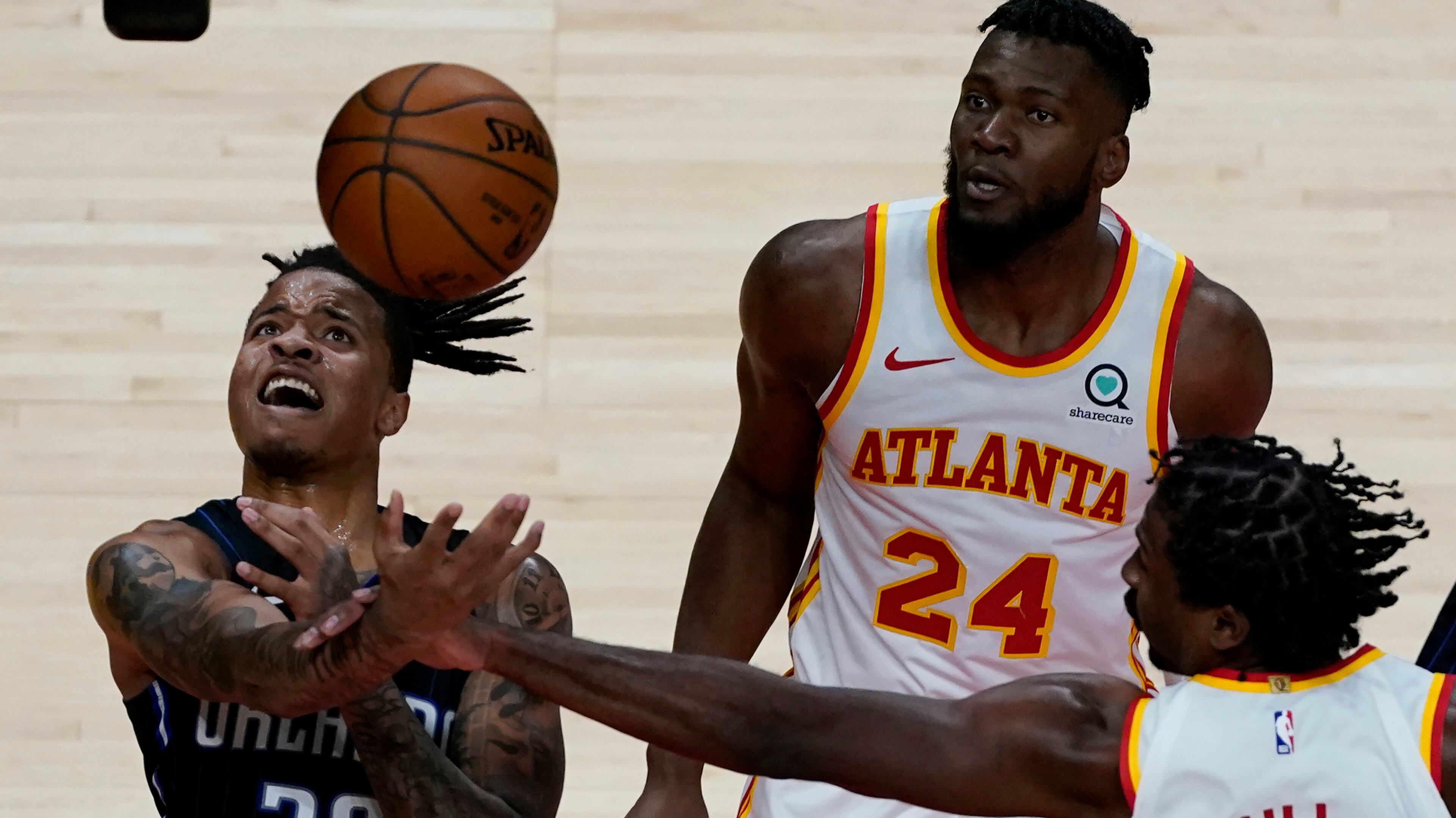 Orlando Magic guard Markelle Fultz (20) loses control of the ball as he drives past Atlanta Hawks' Bruno Fernando (24) and Solomon Hill (18) during the second half Sunday, Dec. 13, 2020, in Atlanta. (John Bazemore/AP)