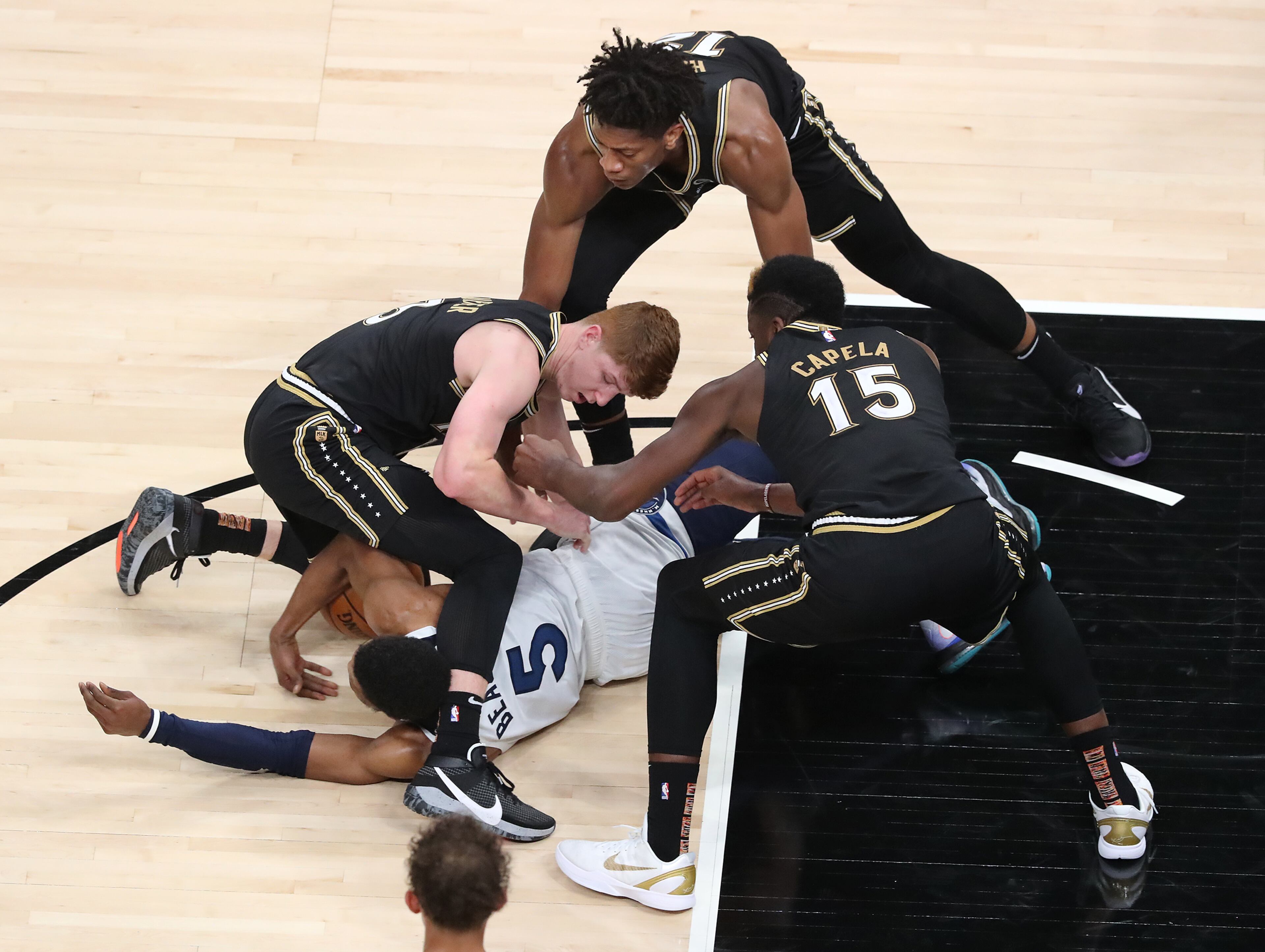 Atlanta Hawks defenders Kevin Huerter (clockwise from left), De’Andre Hunter and Clint Capela force a jump ball as they defend Minnesota Timberwolves guard Malik Beasley Monday, Jan. 18, 2021, at State Farm Arena in Atlanta. (Curtis Compton / Curtis.Compton@ajc.com)