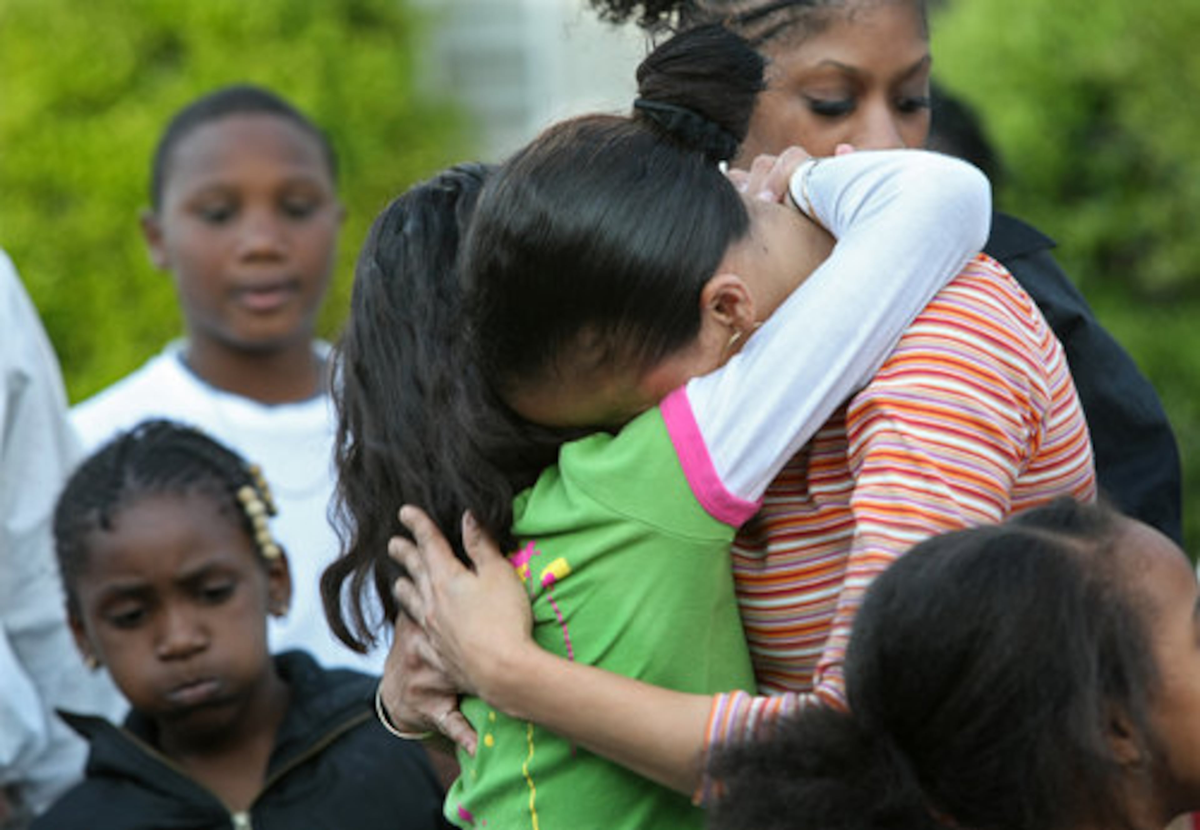 Masika Bermudez is comforted by her husband Norman Keene and her children, Yeiralis, 10, left in green shirt, and Ny'irah, as they are joined by family and friends in a "prayer circle" to remember her fifth-grade son.