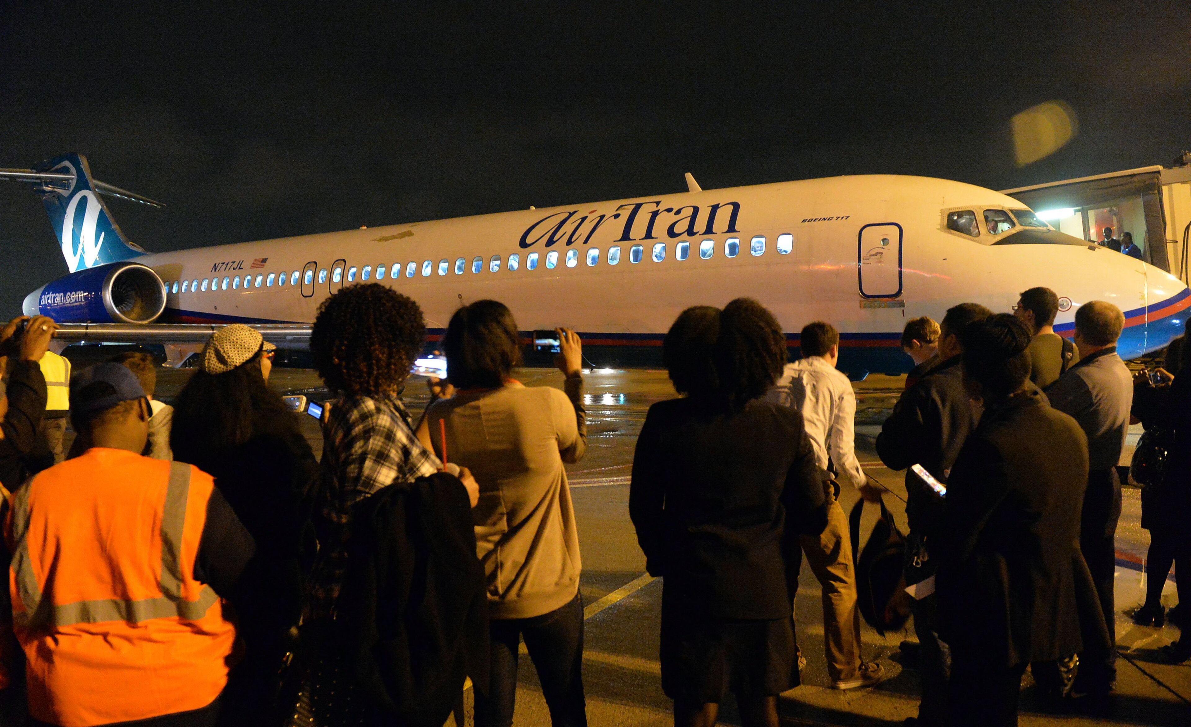 Employees gather on the tarmac for the final flight. Hundreds of Southwest Airlines and former Airtran Airways employees gathered at Concourse C, gates 1, 2 and 3 to celebrate the departure of Airtran’s final flight to Tampa FL, at Hartsfield-Jackson International Airport, Sunday, December 28, 2014. Southwest CEO Gary Kelly and executives Bob Jordan and Jack Smith gave remarks during the program. The full flight was waved off by employees that gathered on the tarmac as crash trucks from Atlanta Fire Rescue gave a final water cannon salute as the plane departed. KENT D. JOHNSON/KDJOHNSON@AJC.COM