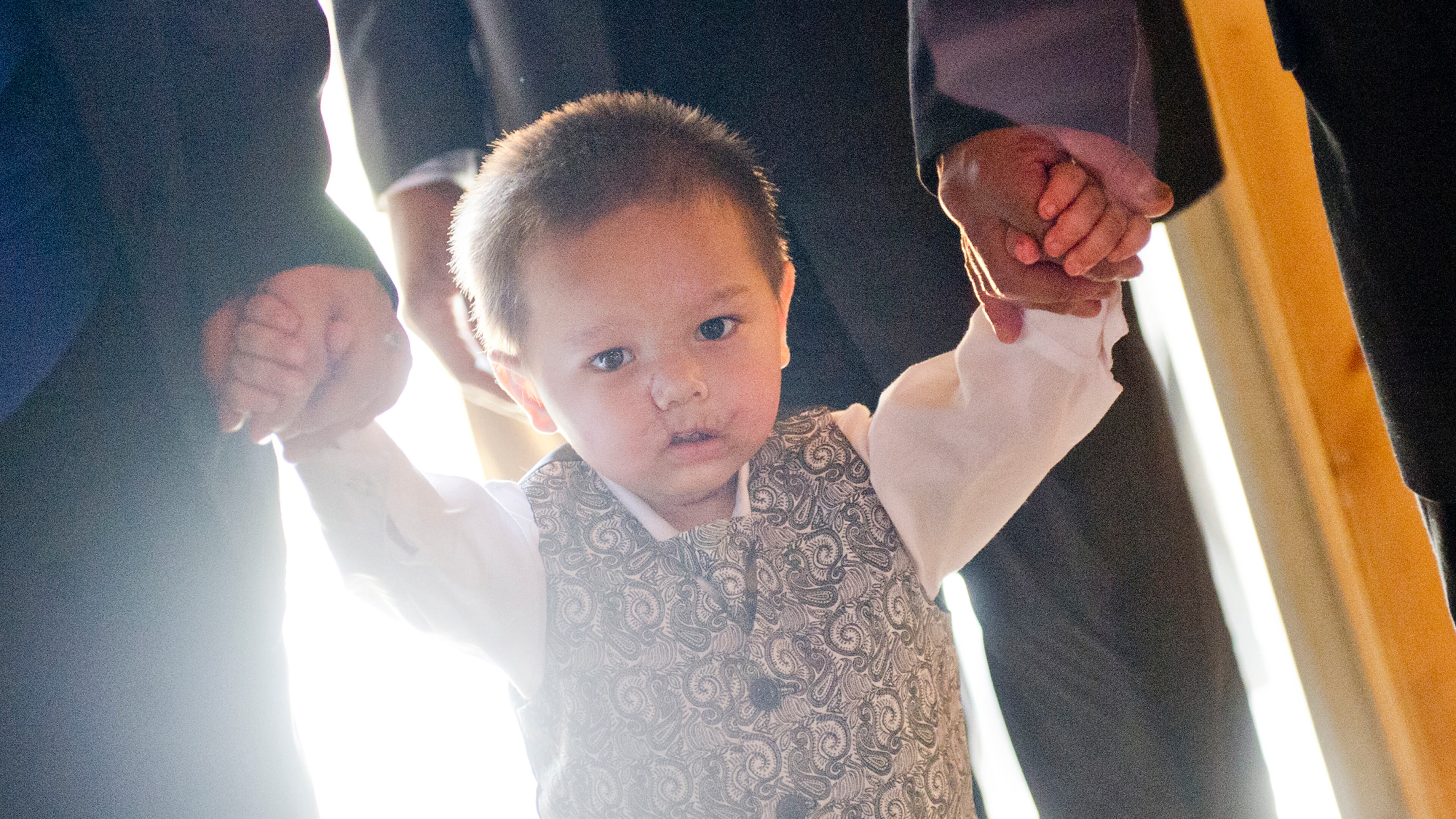 July 2, 2014 Atlanta - Bounkham Phonesavanh (center) holds onto his mother Alecia's and father Bounkham Sr.'s hands as they walk to their table during a farewell breakfast at Delightful Eatz in Atlanta on Wednesday, July 2, 2014. Known as Baby Bou Bou, the young child has been in the hosital for the past five weeks after a botched drug raid in Habersham County. The family is moving back to Wisconsin later this week. JONATHAN PHILLIPS / SPECIAL
