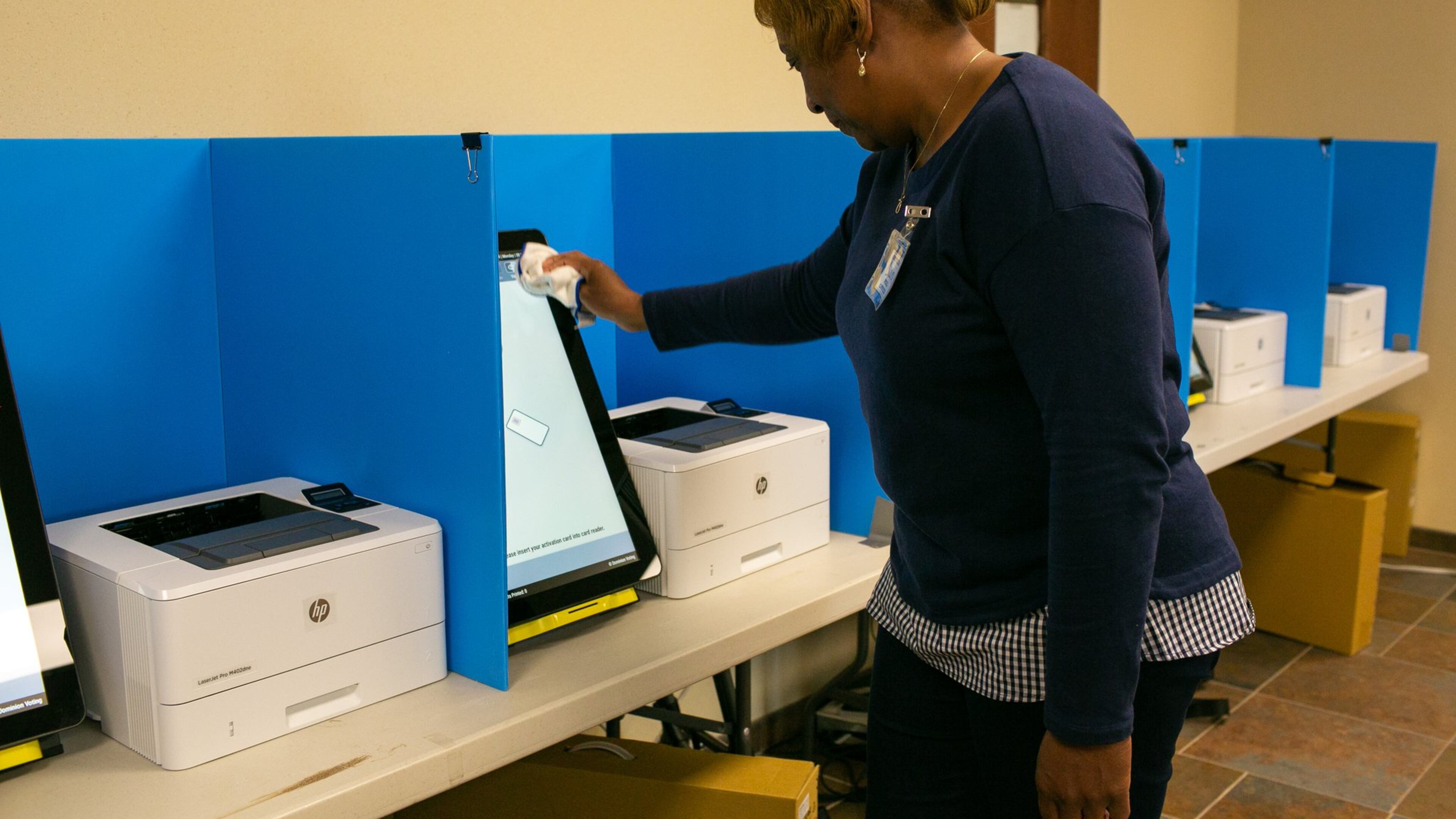 A polling assistant cleans a voting machine at the Paulding County Municipal Building on Oct. 14 in Dallas, Ga. Paulding and six other counties were the first to test the new machines that will be in all precincts in the state for the March 24 presidential primary election. (Photo/Rebecca Wright for the Atlanta Journal-Constitution)