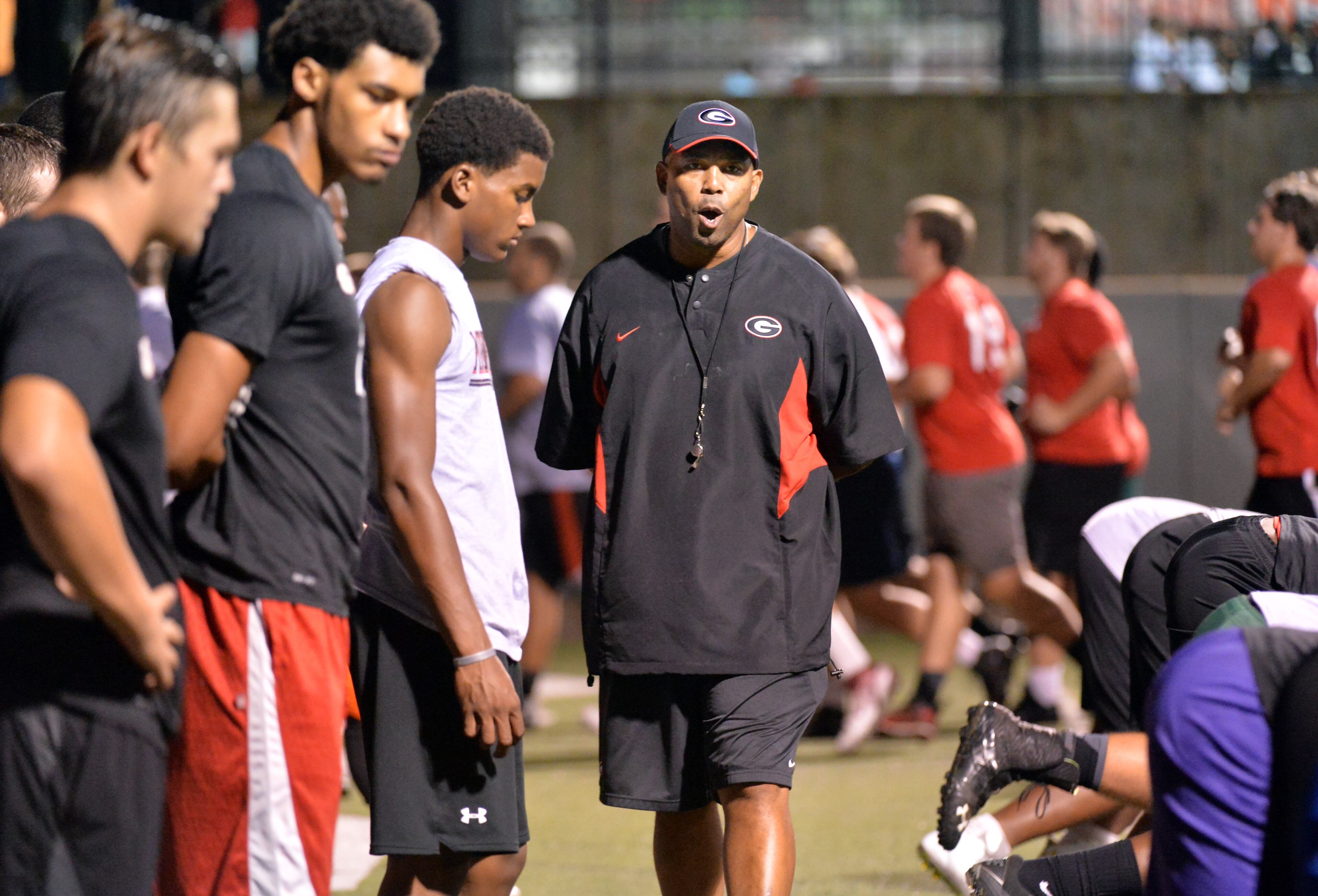New UGA defensive line coach Chris Wilson (right) is trying to convince 4-star DT Dontavious Russell to commit again to the Bulldogs. Auburn is the main competition