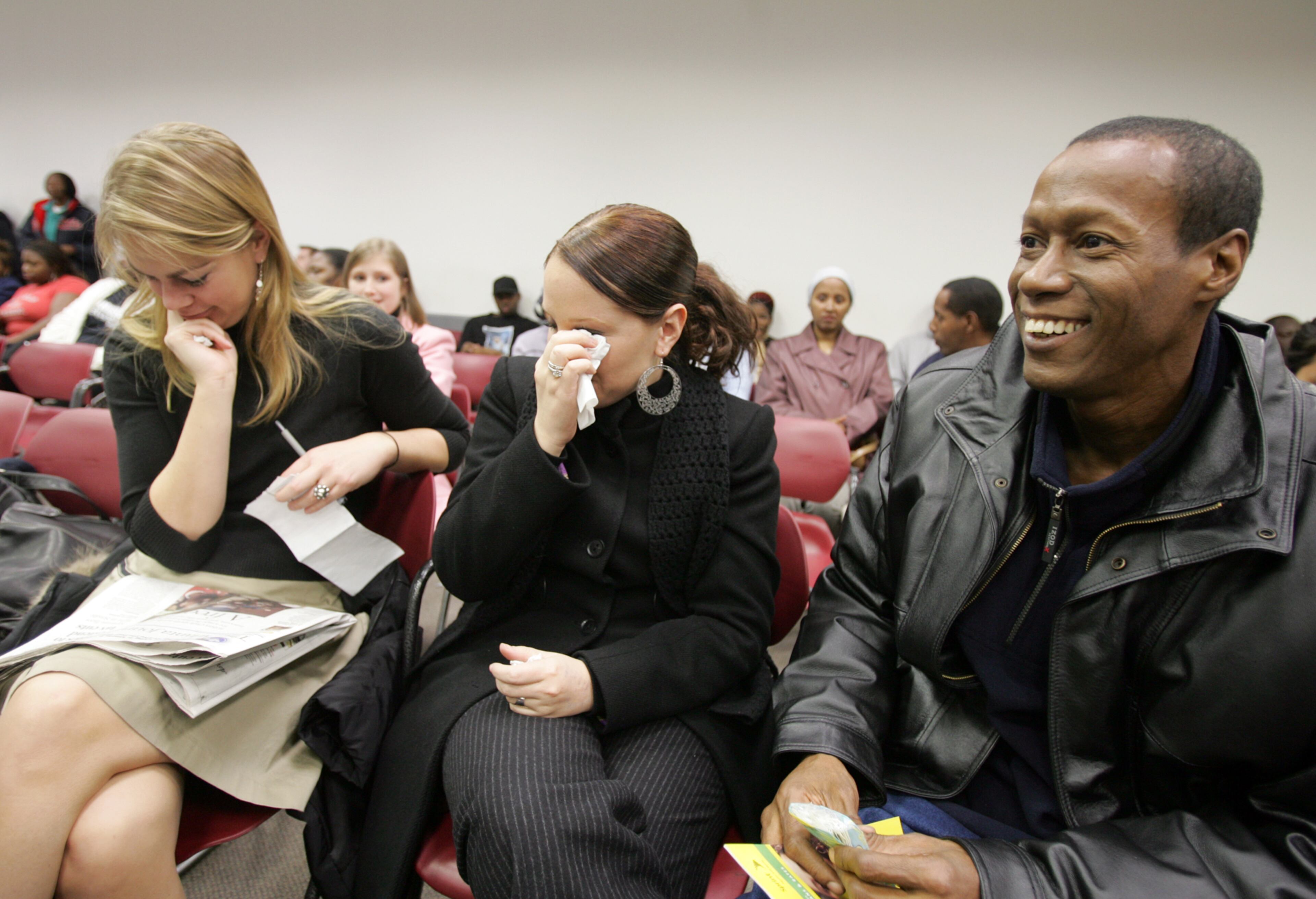 On his first day of freedom in 2005, Robert Clark (far right) kept a smile on his face even while waiting in line at the motor vehicles office to get an ID. AJC FILE
