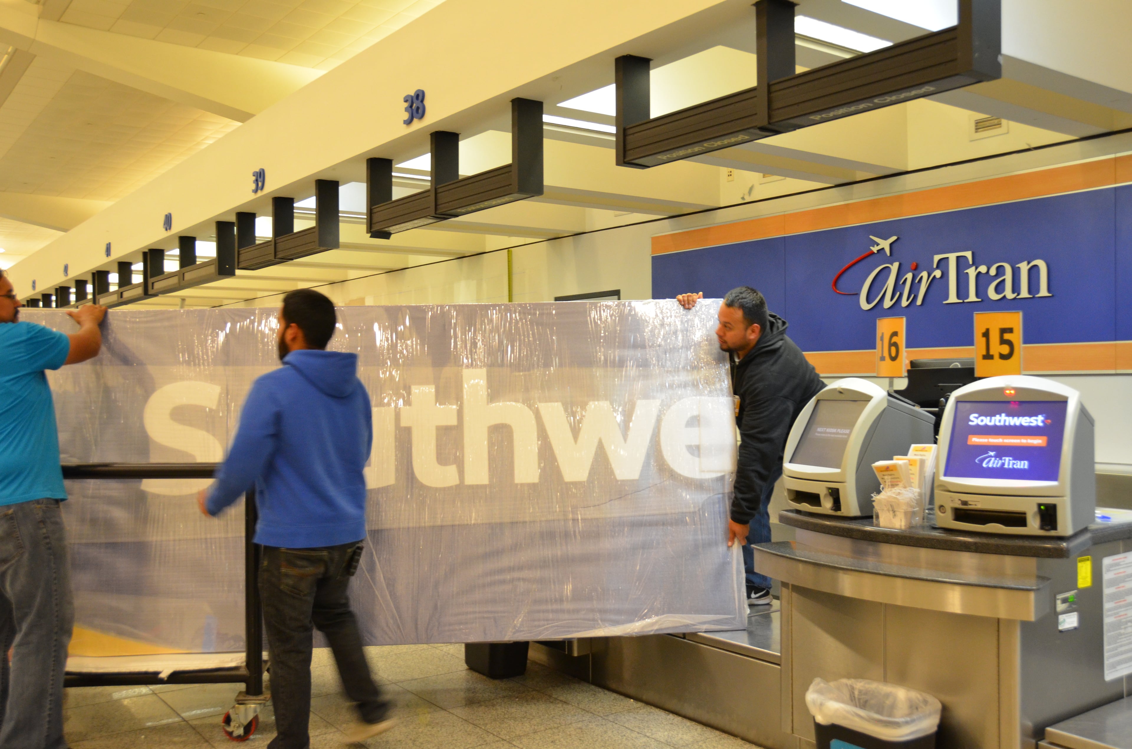 Contractors for Southwest Airlines took down the AirTran Airways signs at Hartsfield-Jackson International Airport, removing some of the last vestiges of the name at AirTran's former Atlanta hub. Dallas-based Southwest, which acquired AirTran in 2011 and has been gradually integrating AirTran's operations into its own, is replacing the signs with its own new logo. AirTran's final flight will be in late December, after which the AirTran name will disappear into the annals of aviation history.