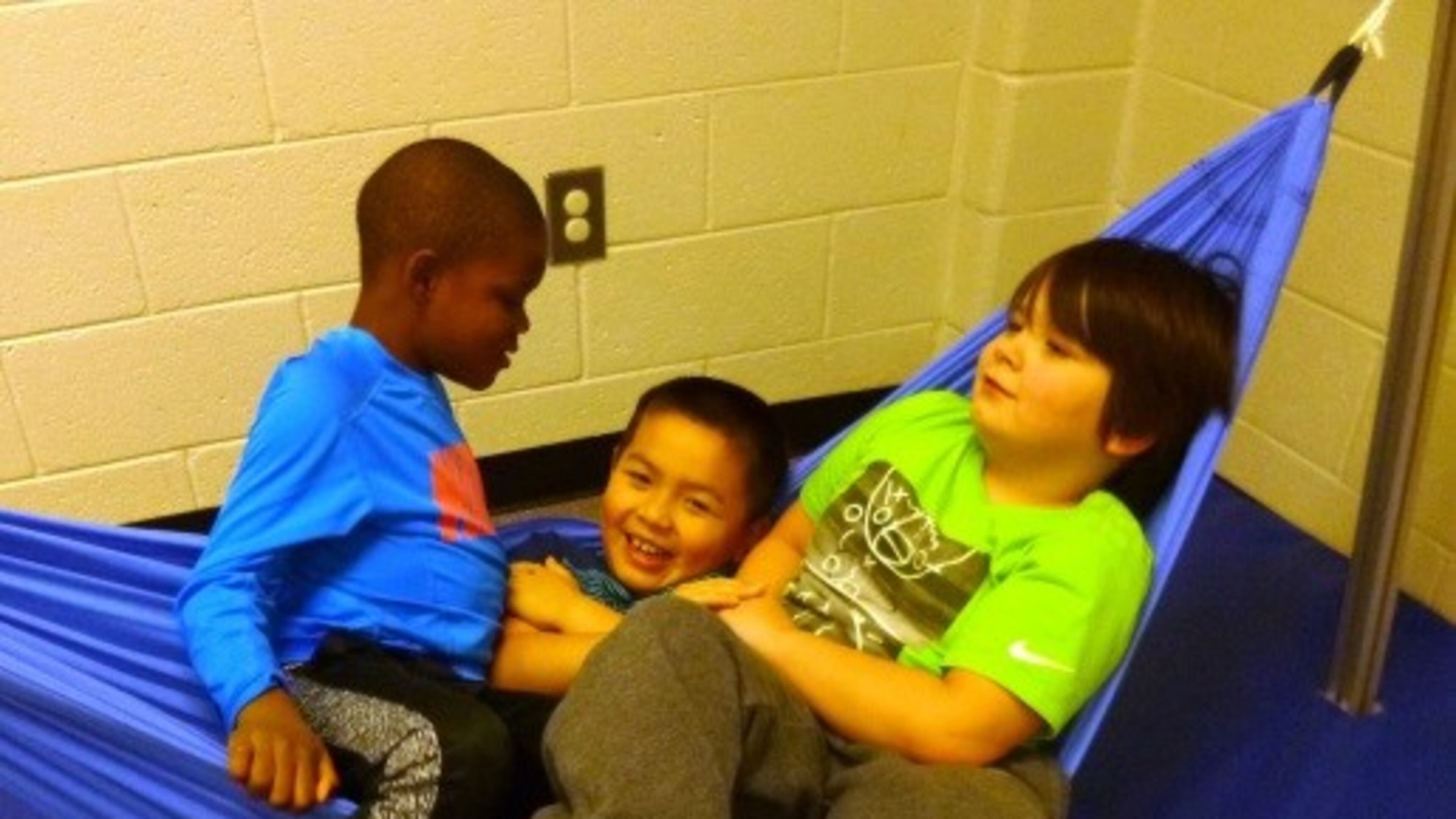 Students in Lisa Trantham's second grade special education class sit in the hammock that parent Joe Kain built for them.