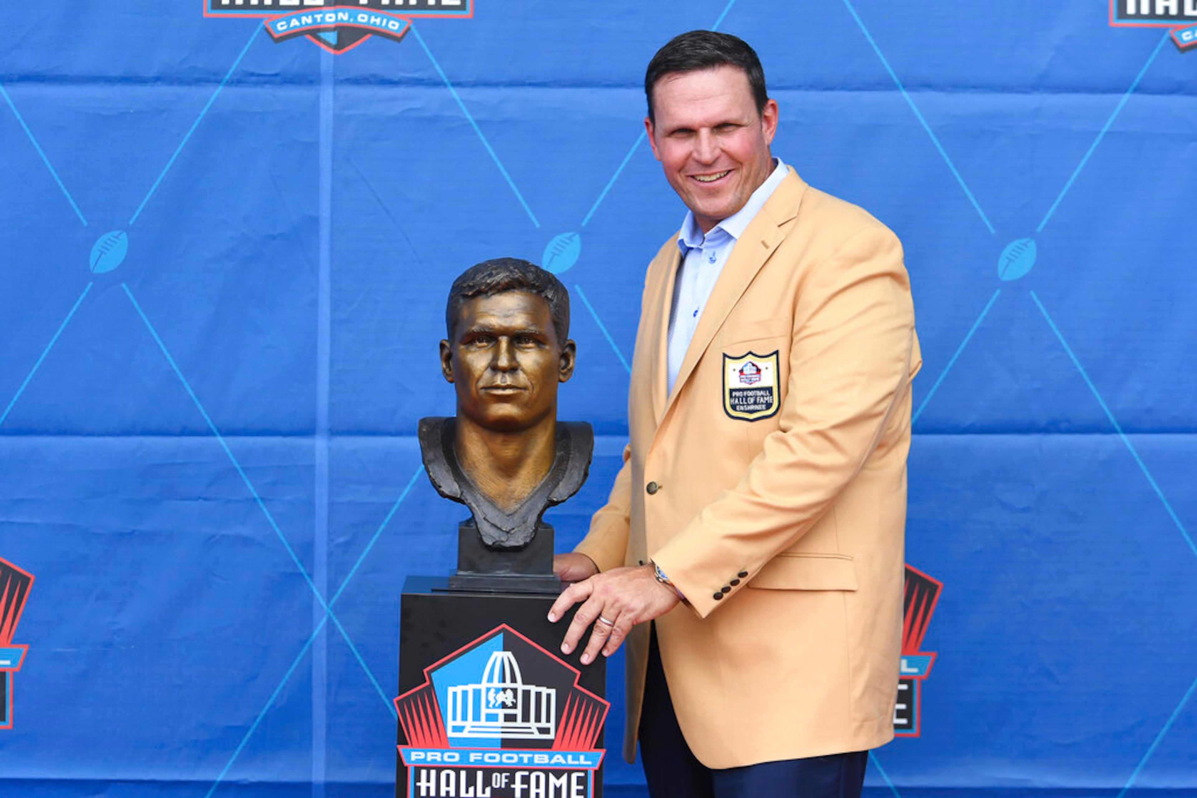 Former NFL player Tony Boselli poses with his bust during an induction ceremony at the Pro Football Hall of Fame in Canton, Ohio, Saturday, Aug. 6, 2022. (AP Photo/David Dermer)