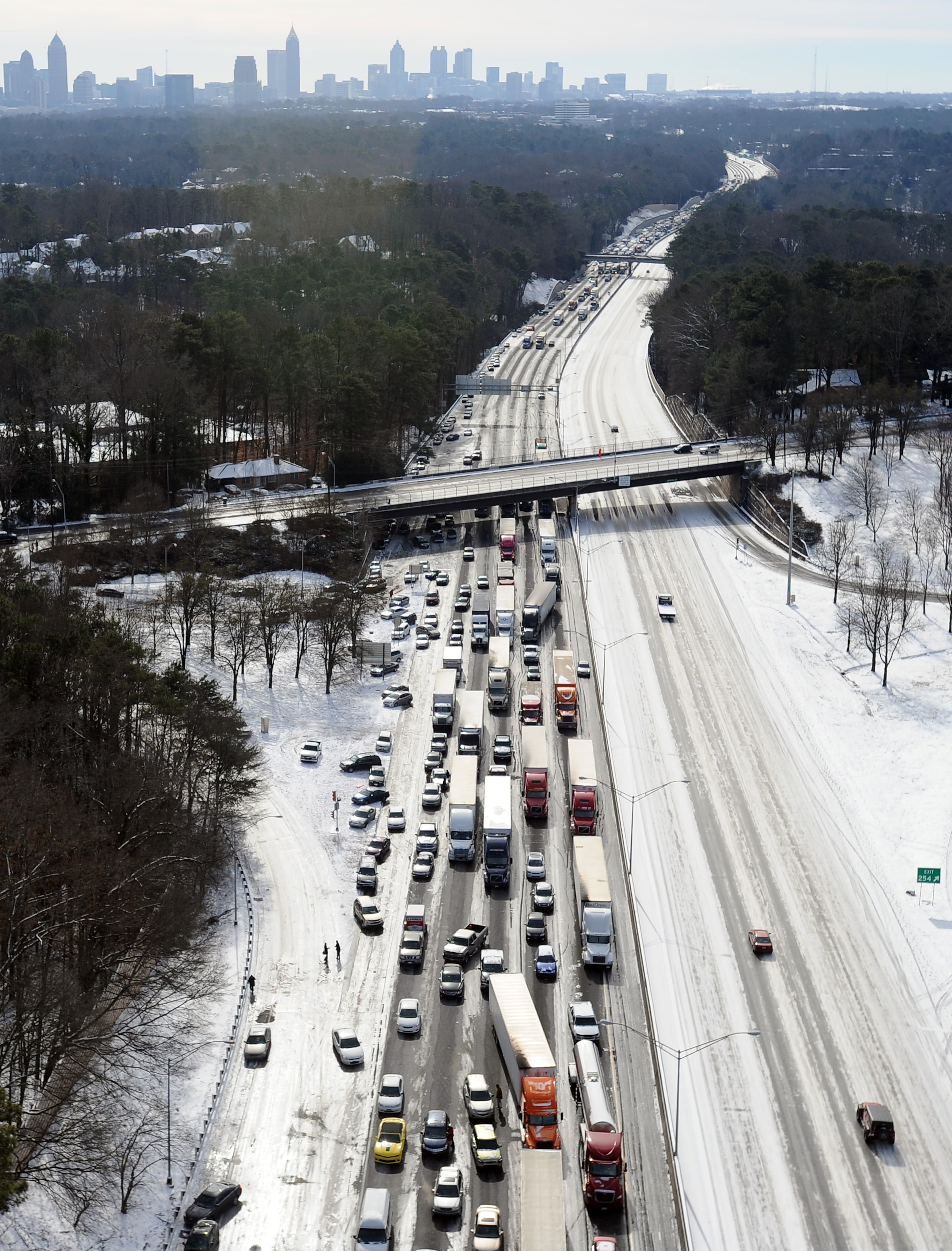 In this aerial view looking at I-75 north at Moores Mill Rd., some motorists leave their vehicles along the ice-covered interstate after a winter snow storm Wednesday, Jan. 29, 2014, in Atlanta.
