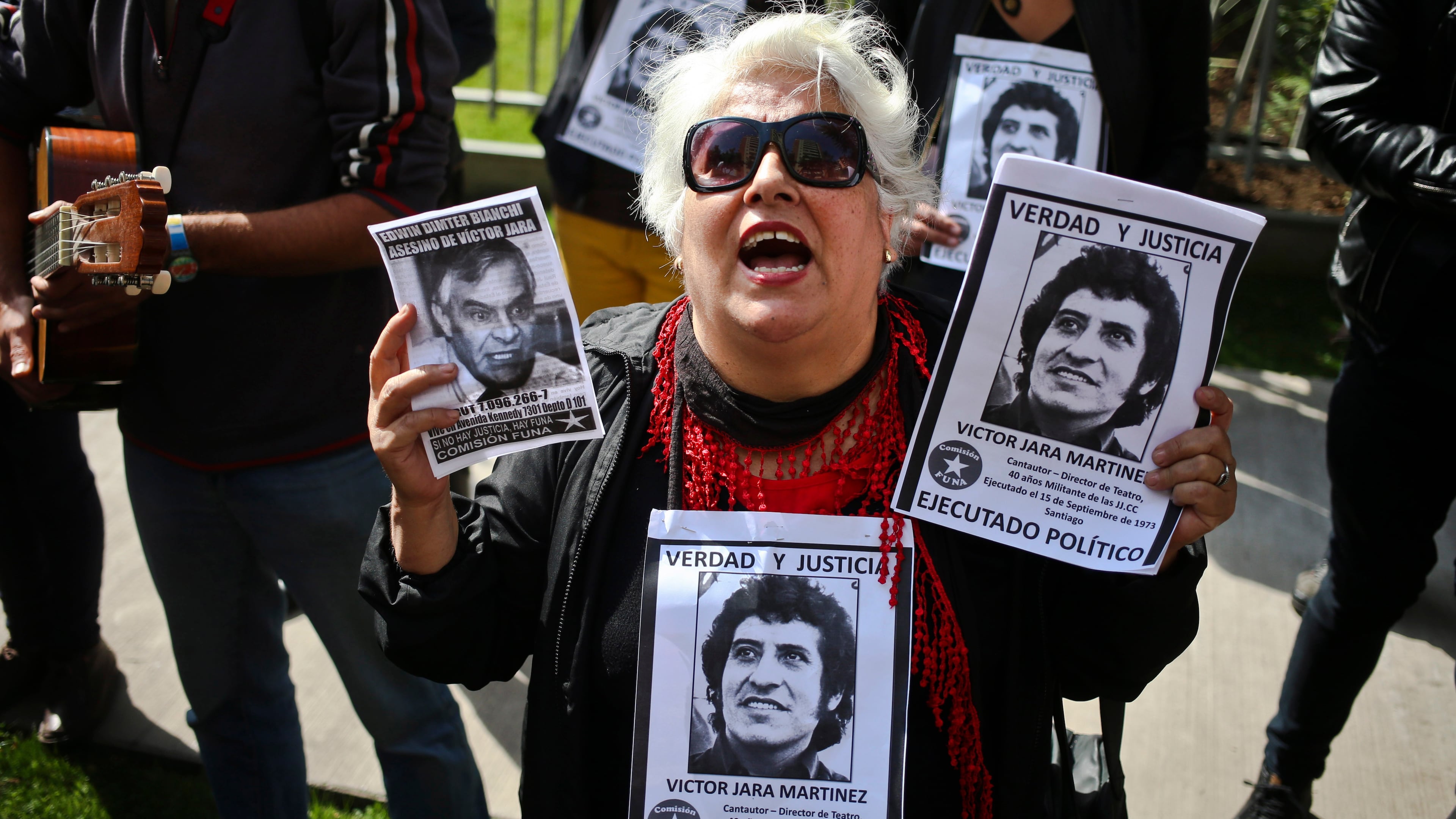 FILE -Members of the Funa Commission shout slogans outside the home of Edwin Dimter Bianchi, accused and on trial for the murder of Chilean singer-songwriter Victor Jara, during a demonstration to publicly shame him in Santiago, Chile, April 22, 2017. (AP Photo/Esteban Felix, File)