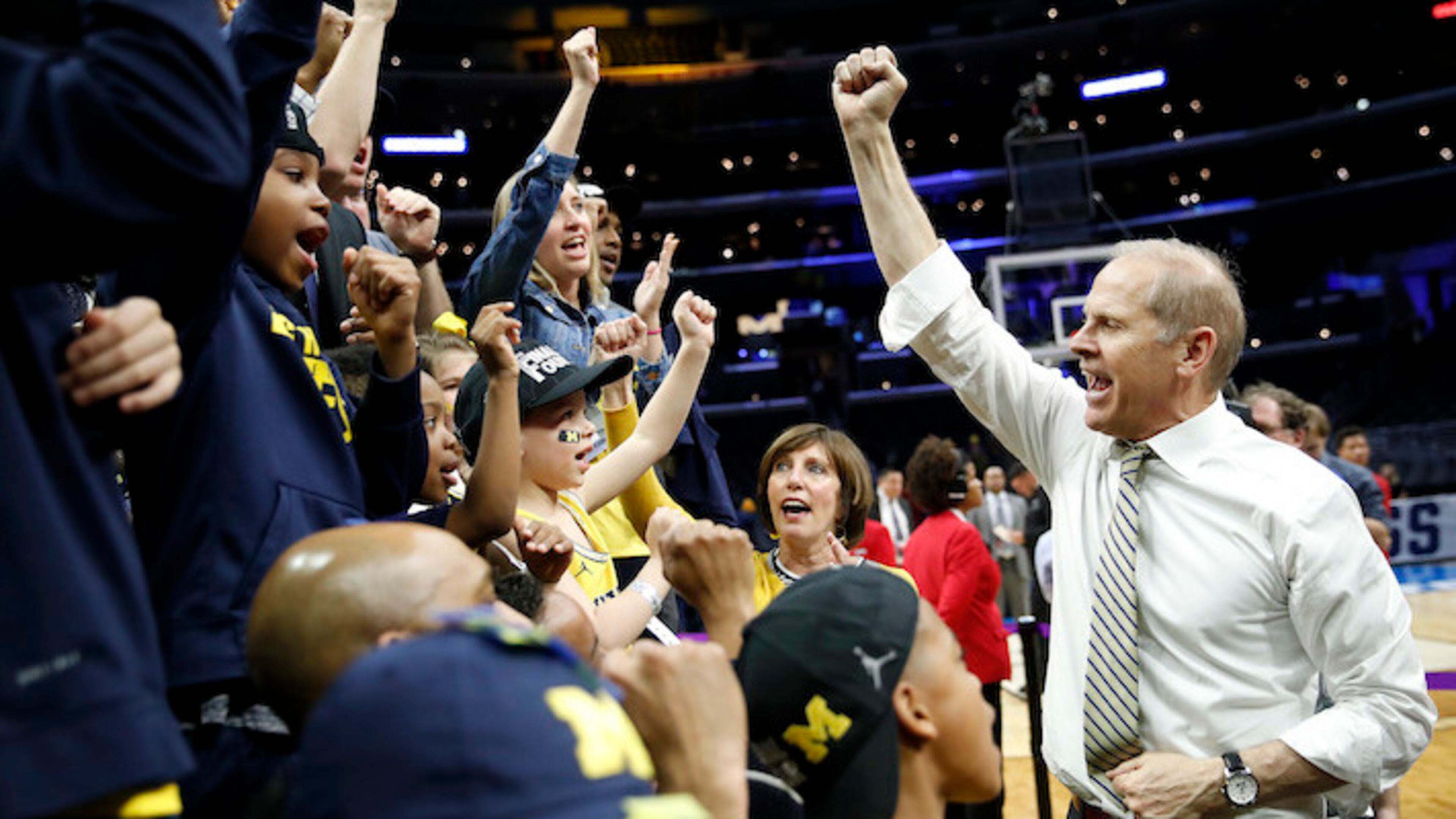 Michigan coach John Beilein, right, celebrates with players, coaches and family after Michigan defeated Florida State 58-54 in an NCAA men's college basketball tournament regional final Saturday, March 24, 2018, in Los Angeles. (AP Photo/Jae Hong)