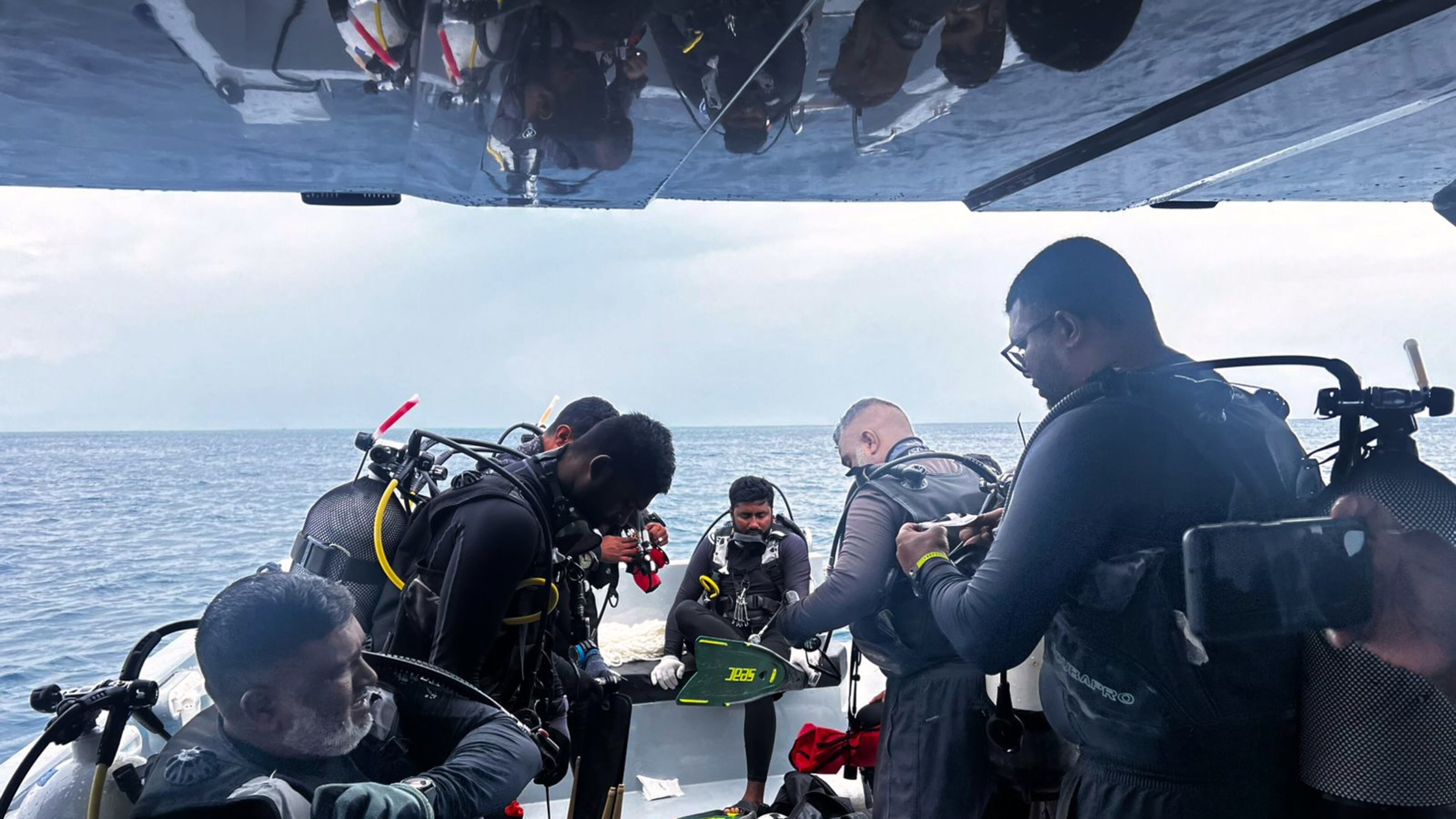 This image released by the Maldives President's Media Division, shows divers preparing to search for the four missing Italian divers near Alimathaa Island, Vaavu Atoll, Maldives, Saturday, May 15, 2026. (Maldives President's Media Division via AP)