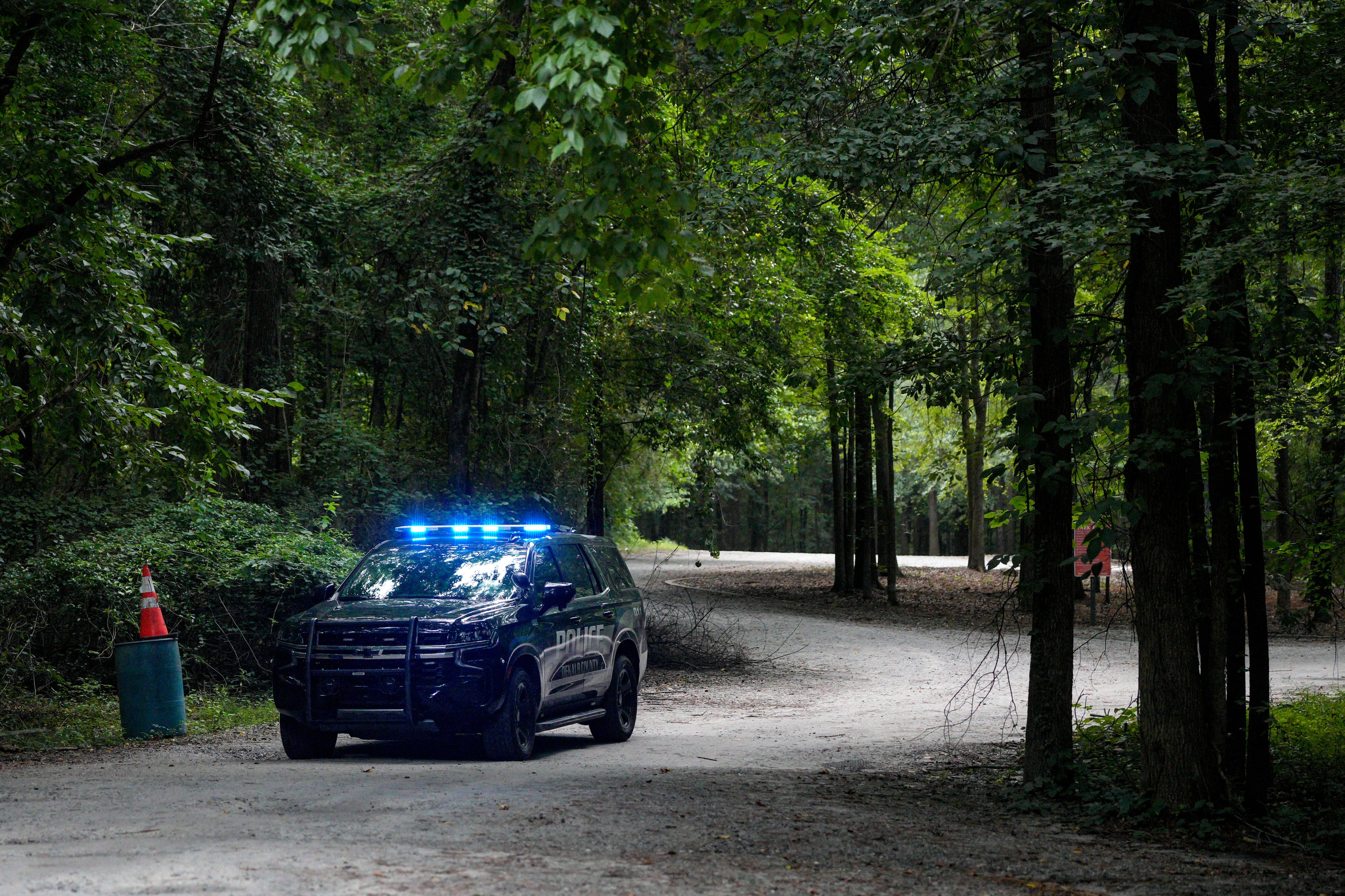 A police cruiser sits near the parking lot at Constitution Lakes Park close to the start of the Doll's Head Trail. (Ben Hendren for The Atlanta Journal-Constitution)