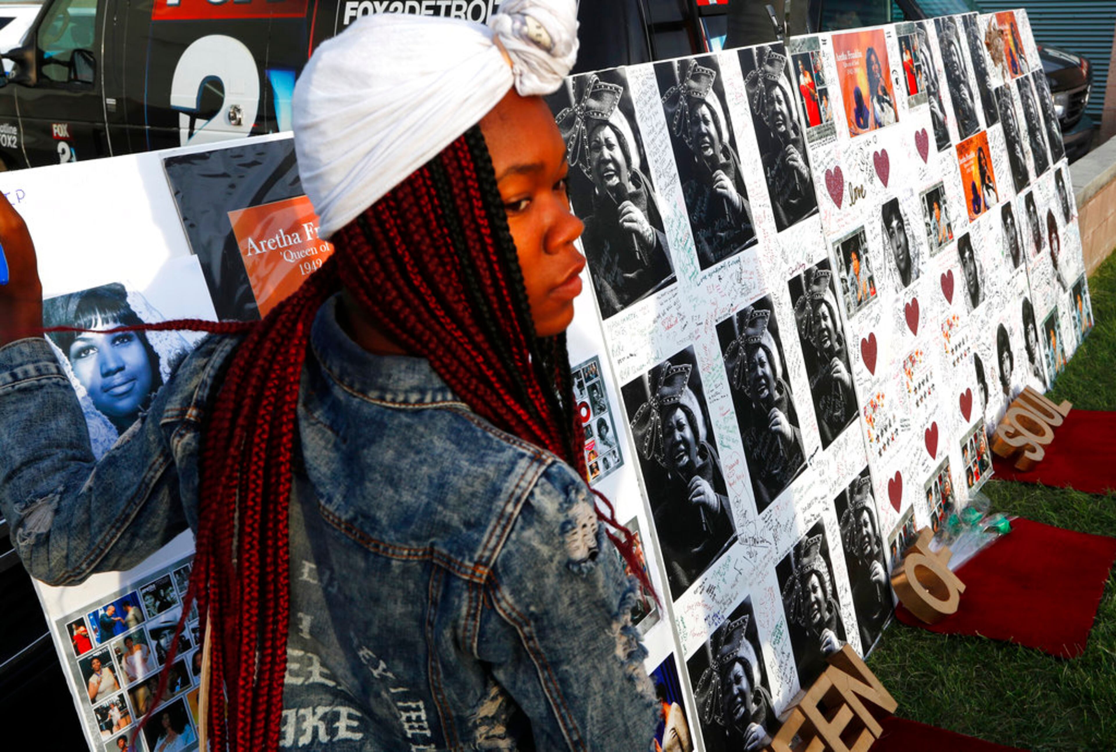 A woman signs a poster outside the Charles H. Wright Museum of African American History during a public visitation for Aretha Franklin in Detroit, Wednesday, Aug. 29, 2018. Franklin died Aug. 16, of pancreatic cancer at the age of 76. (AP Photo/Paul Sancya)