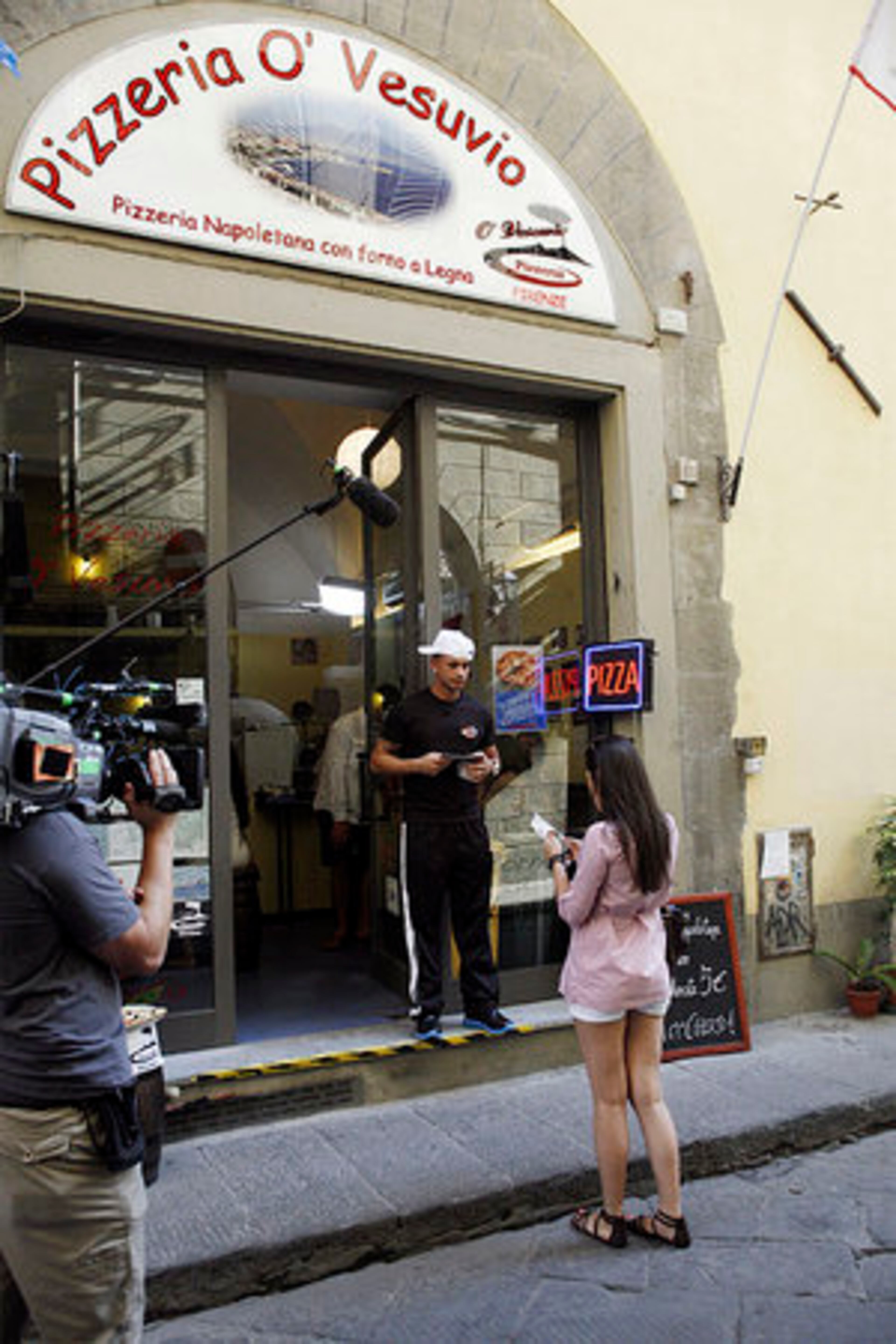 Paul "Pauly D" Del Vecchio talks with a woman outside O' Vesuvio pizzeria in Florence, Italy.
