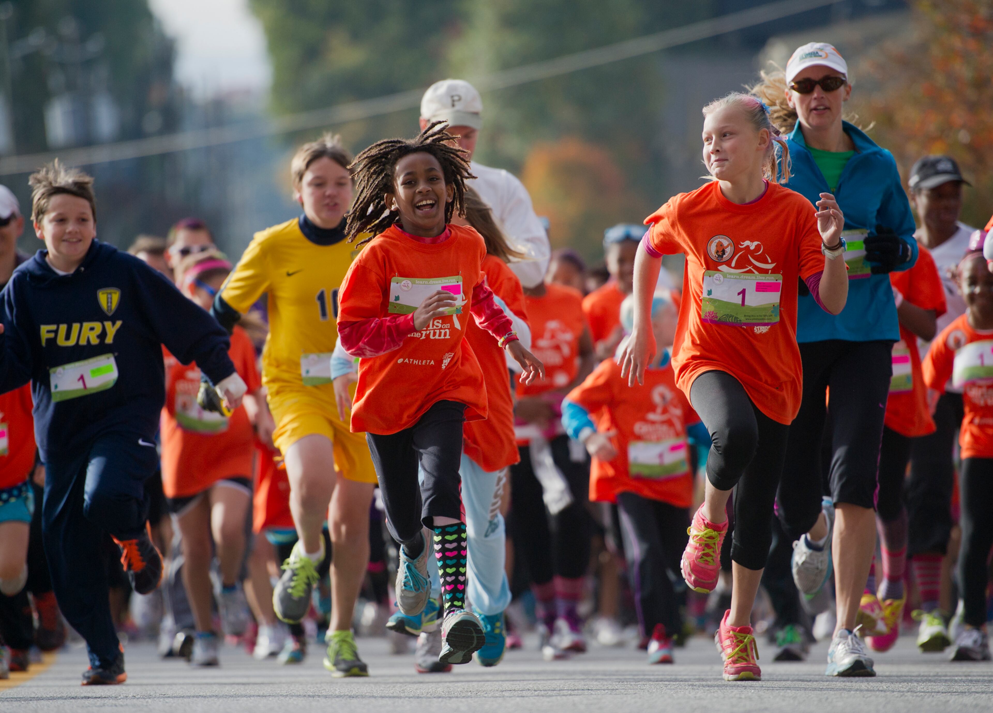 Abezu Kucik (center) runs alongside Jordan Kula (right) during the 2013 Girls on the Run 5K at Atlantic Station in Atlanta on Nov. 10, 2013.