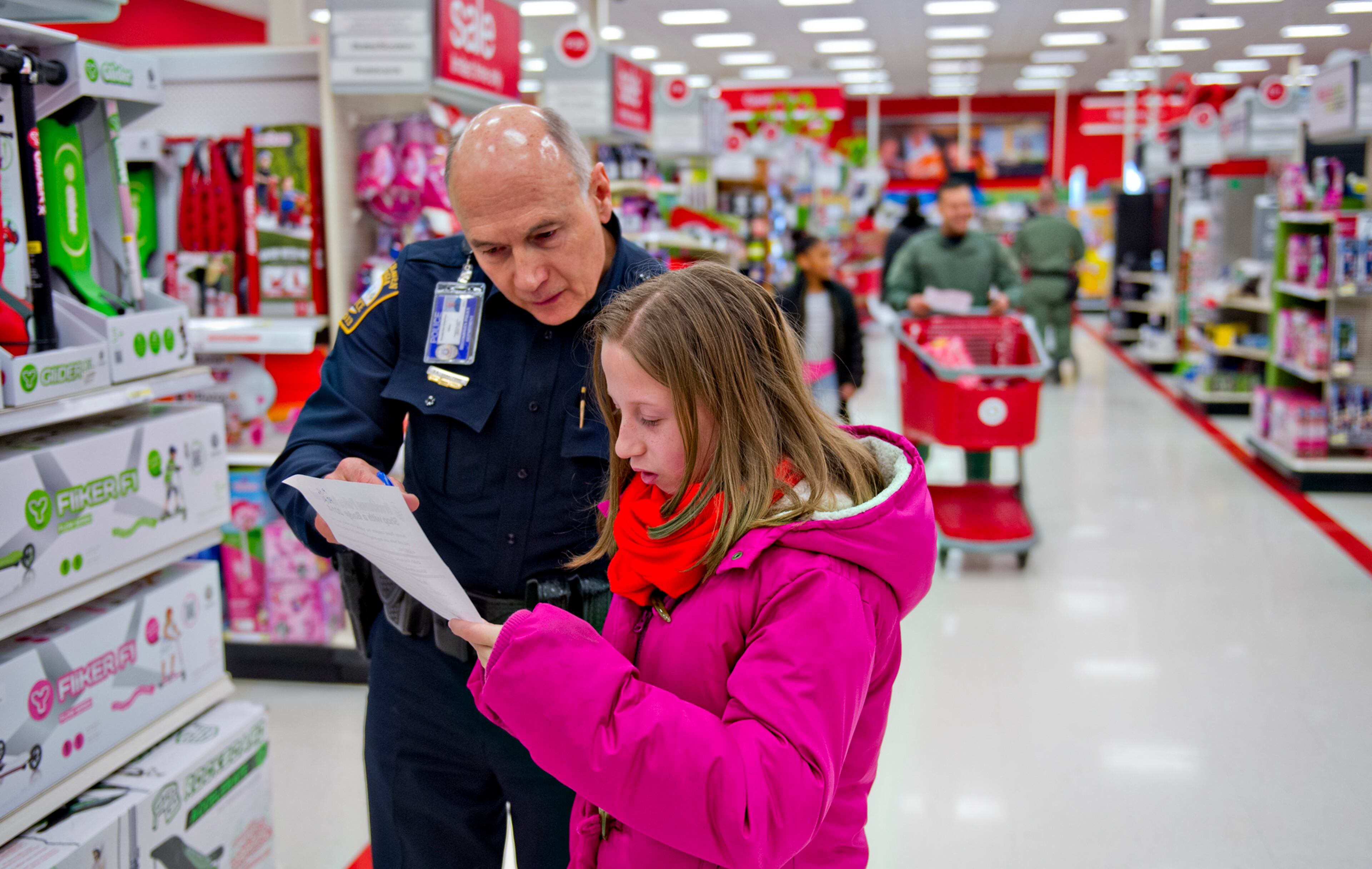 December 13, 2014 Atlanta - Brookhaven Police Ofc. Drake Ford (left) and Ashlyn Moody look at her wish list as they shop during the first annual Brookhaven Police Shop with a Badge event at the Target off of North Druid Hills in Atlanta on Saturday, December 13, 2014. Officers from the Brookhaven Police Department teamed up with Target and the Brookhaven Boys $ Girls Club to help 41 children buy presents for Christmas. Each child received a $200 gift card to help buy presents for family members. JONATHAN PHILLIPS / SPECIAL