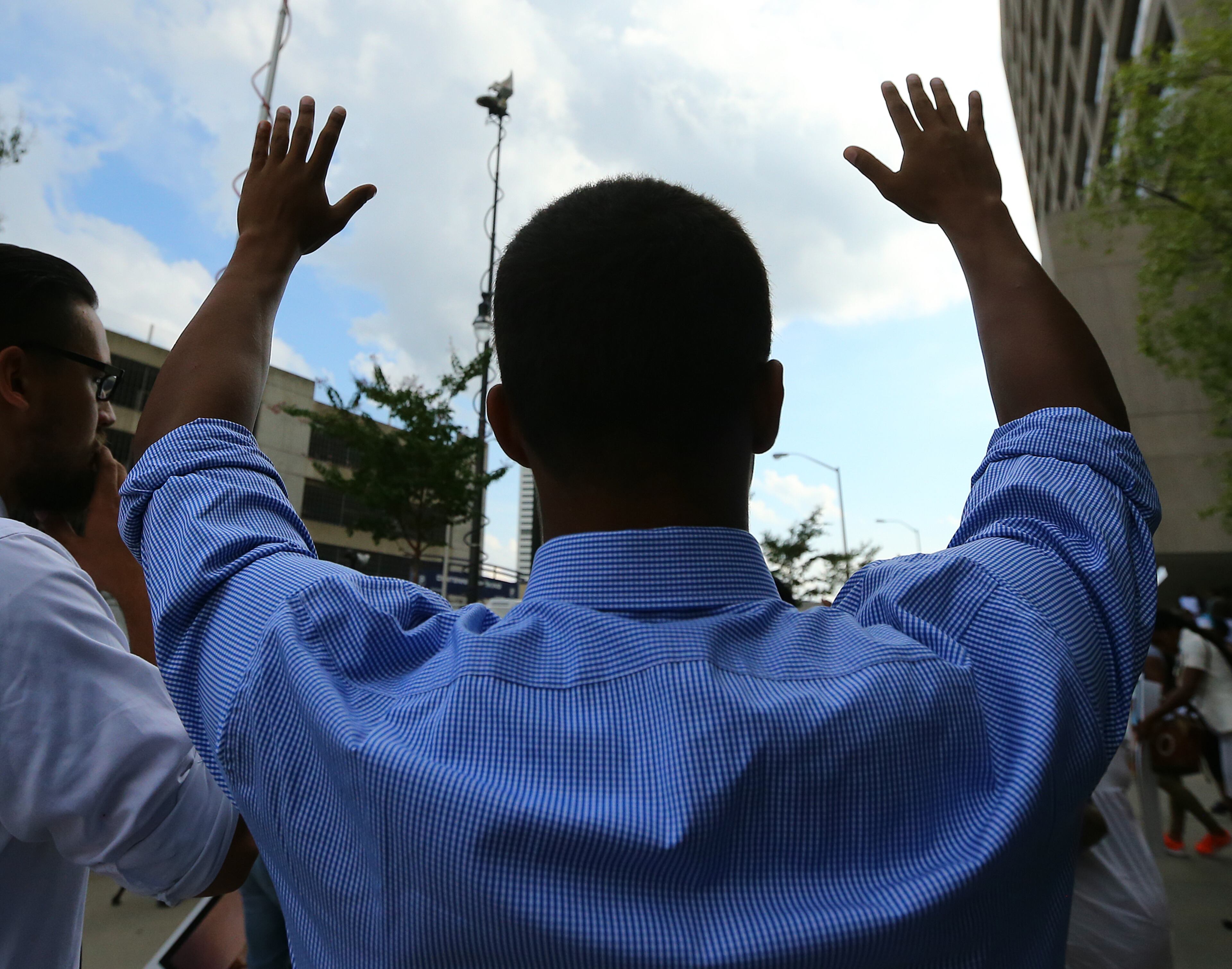 081814 Atlanta: Jordan Adams raises his hands in the air shouting " don't shoot" during a rally for Mike Brown and Ferguson outside the CNN Center on Monday, August 18, 2014, in Atlanta. CURTIS COMPTON / CCOMPTON@AJC.COM