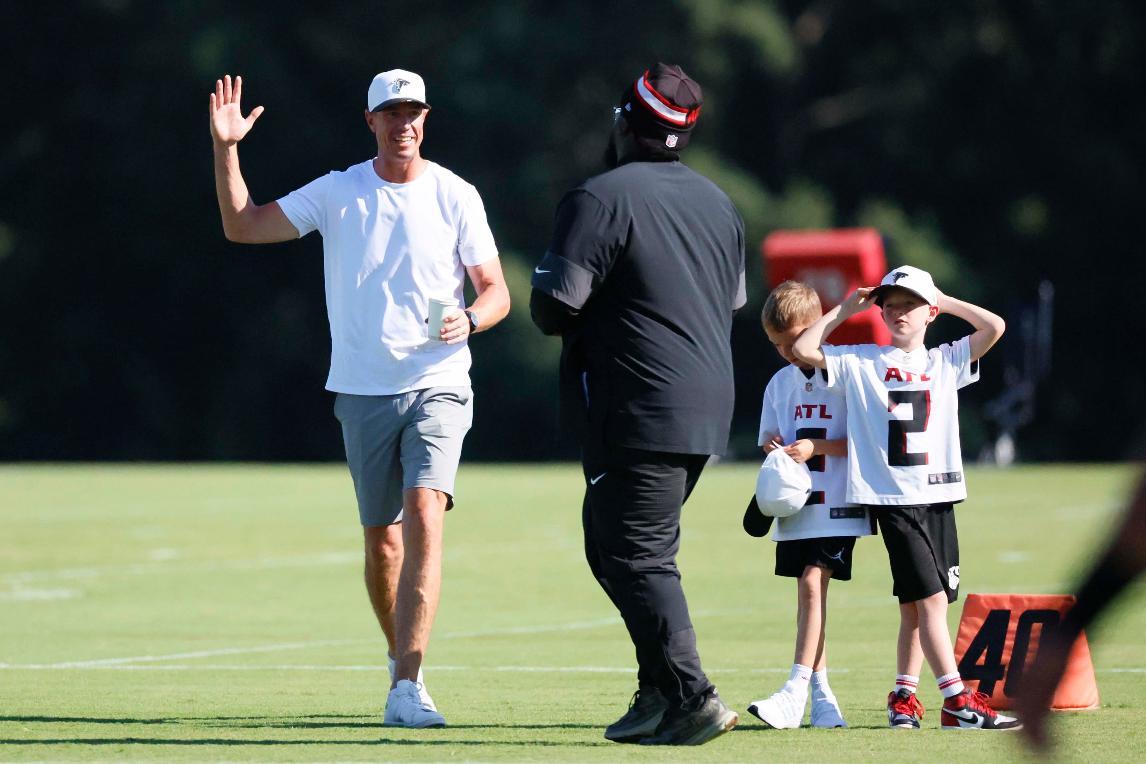 Former Atlanta Falcons quarterback Matt Ryan greets Falcons’ defensive line coach Nate Ollie during training camp at the Falcons Practice Facility on Sunday, July 27, in Flowery Branch.(Miguel Martinez/AJC)