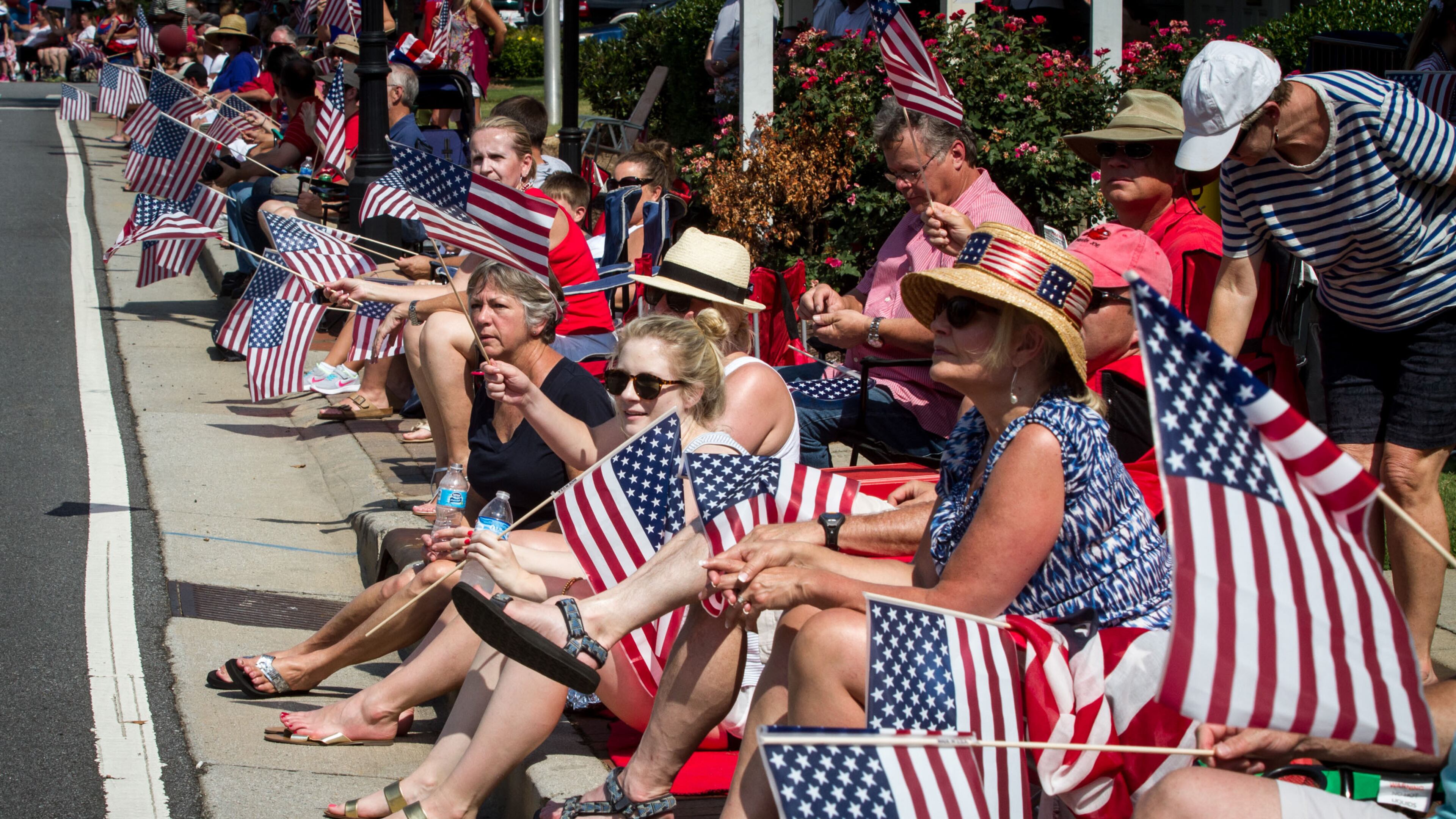 Spectators wave their flags as the Marietta Freedom Parade in Marietta. Steve Schaefer/Special to the AJC