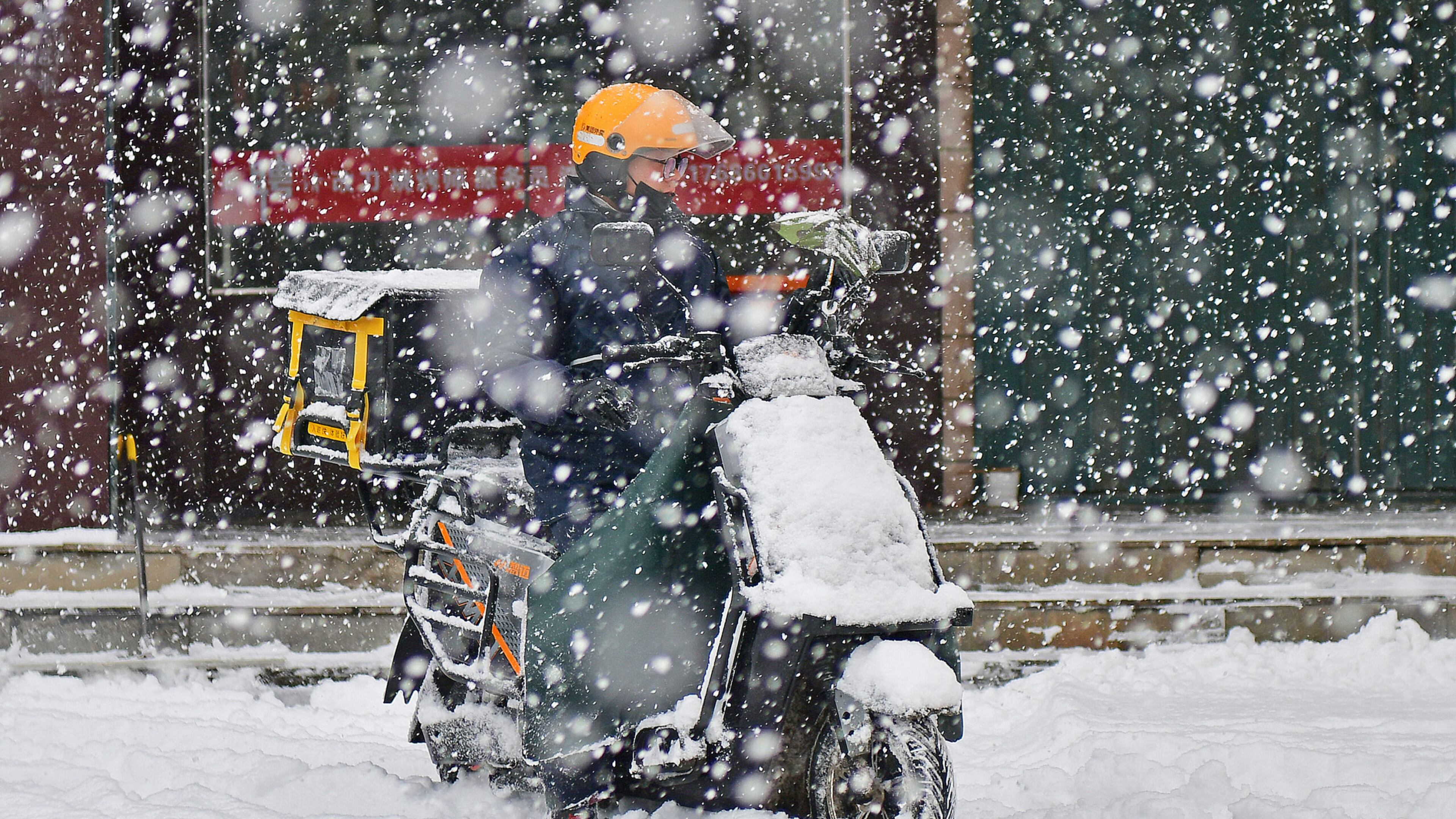 FILE: A food delivery rider is braving the snow in Yantai, Shandong Province, China, on December 20, 2023. (Photo by Costfoto/NurPhoto via Getty Images)