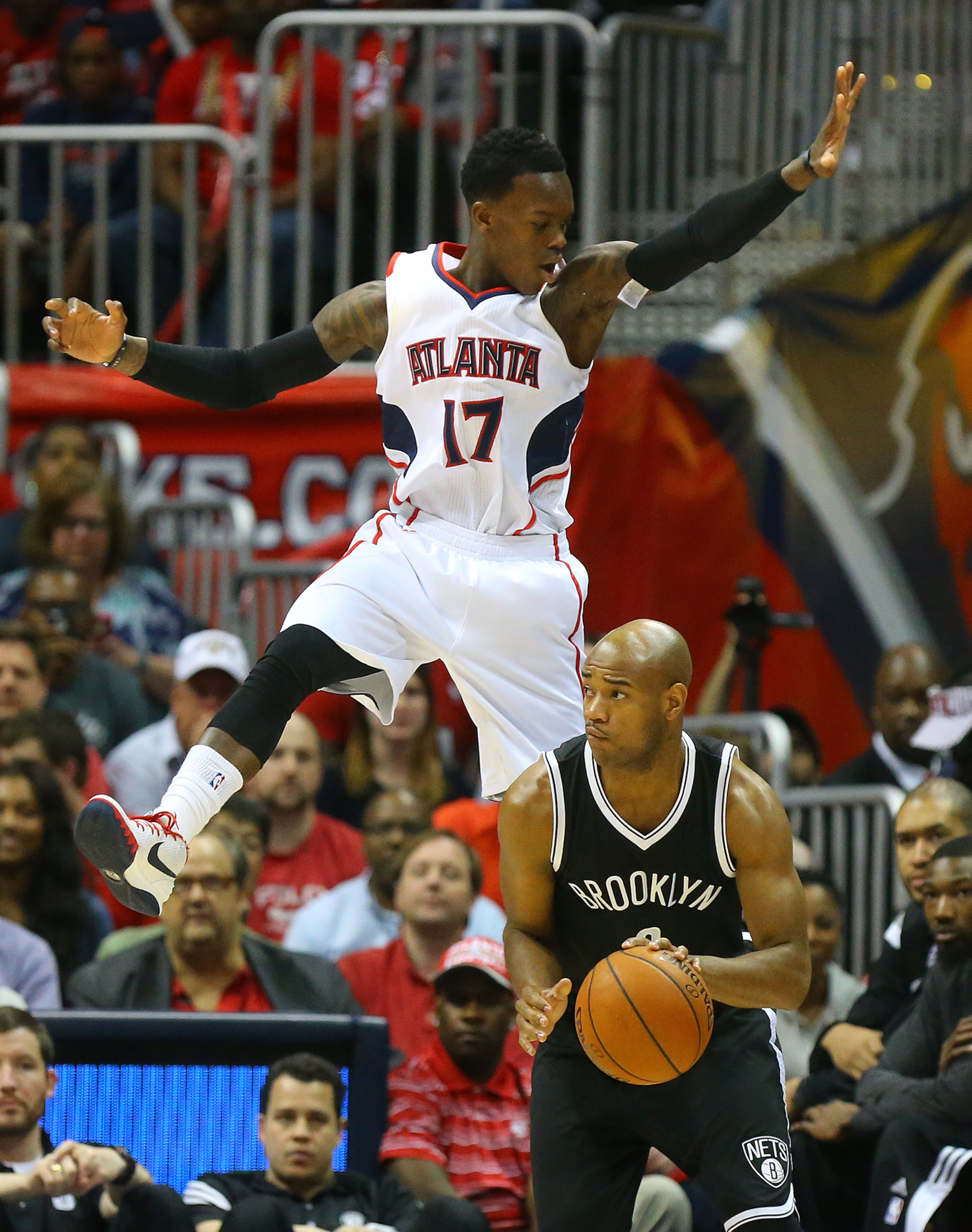 The Hawks' Dennis Schroder goes high defending against the Nets' Jarrett Jack on April 22, 2015. Curtis Compton / ccompton@ajc.com