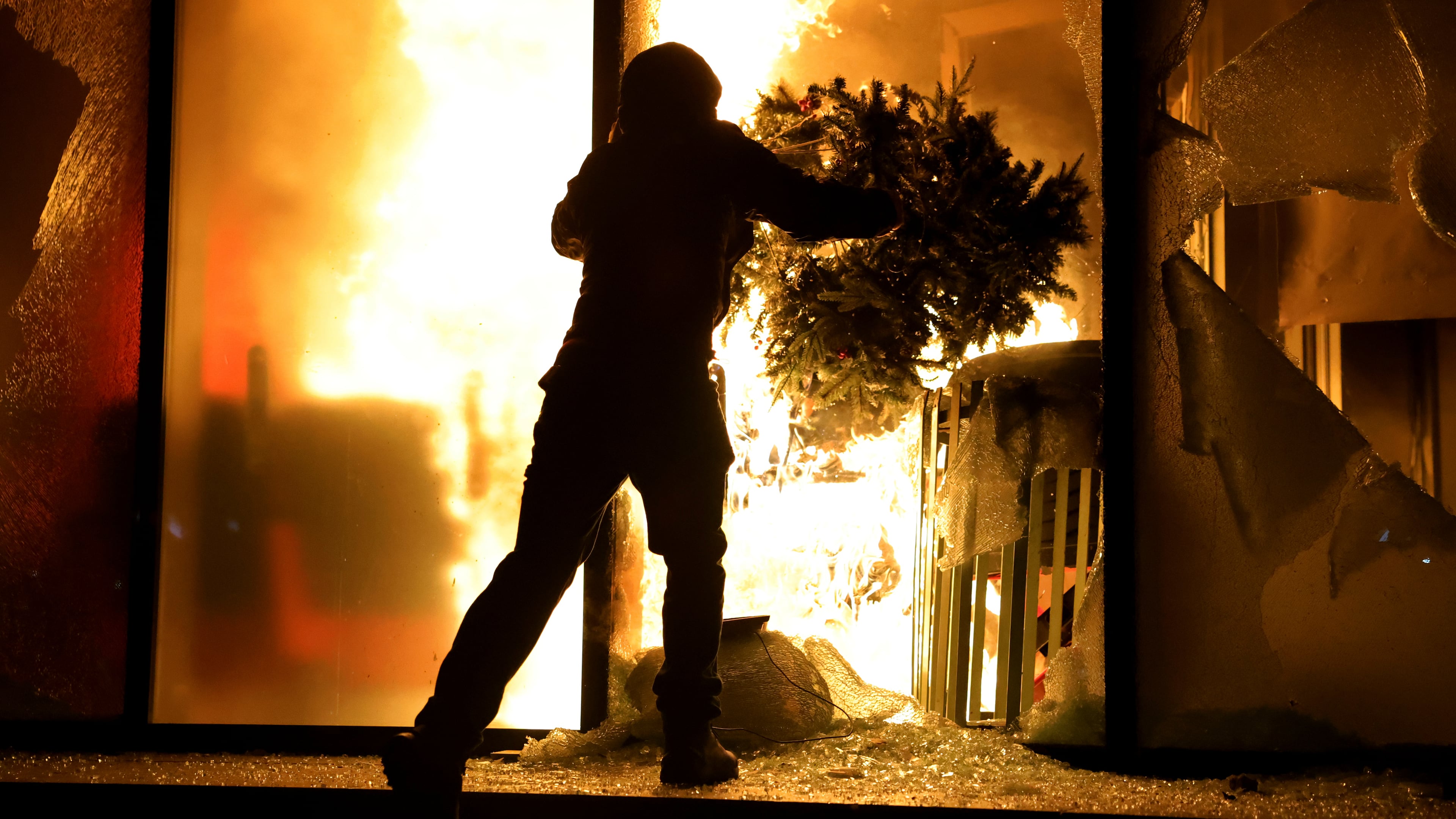 A hooded protester vandalizes the Justice Ministry during clashes in Tirana, Albania, Wednesday, Oct. 14, 2026, as students joined the Flamingo anti-government movement. (AP Photo/Hameraldi Agolli)