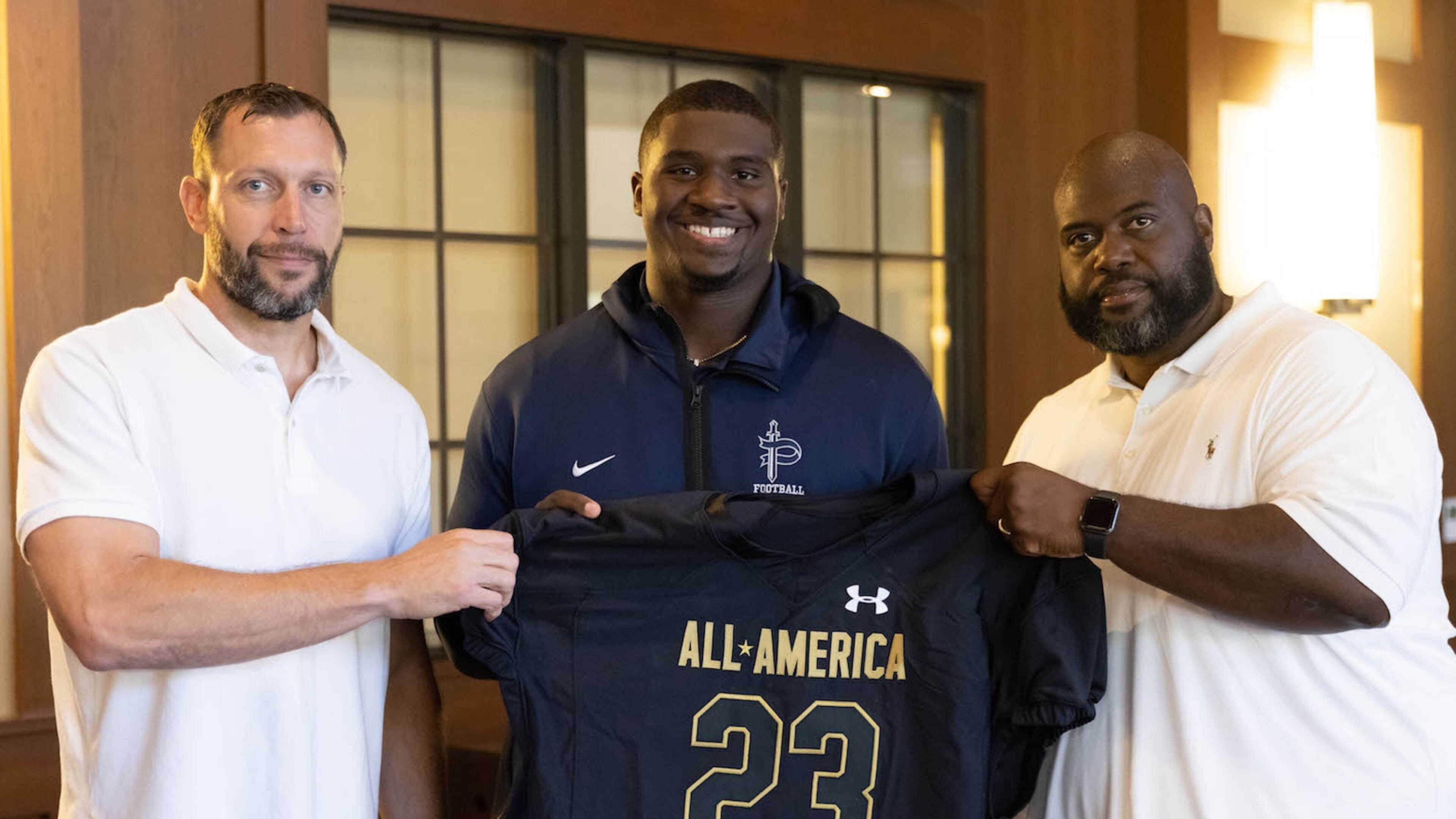 Pace Academy senior Trovon Baugh received his commemorative 2023 Under Armour Next All-America Game jersey on Friday, Oct. 14. He is pictured with Pace Academy Head Coach Nick Bach (left) and Assistant Coach Kevin Johnson (right).