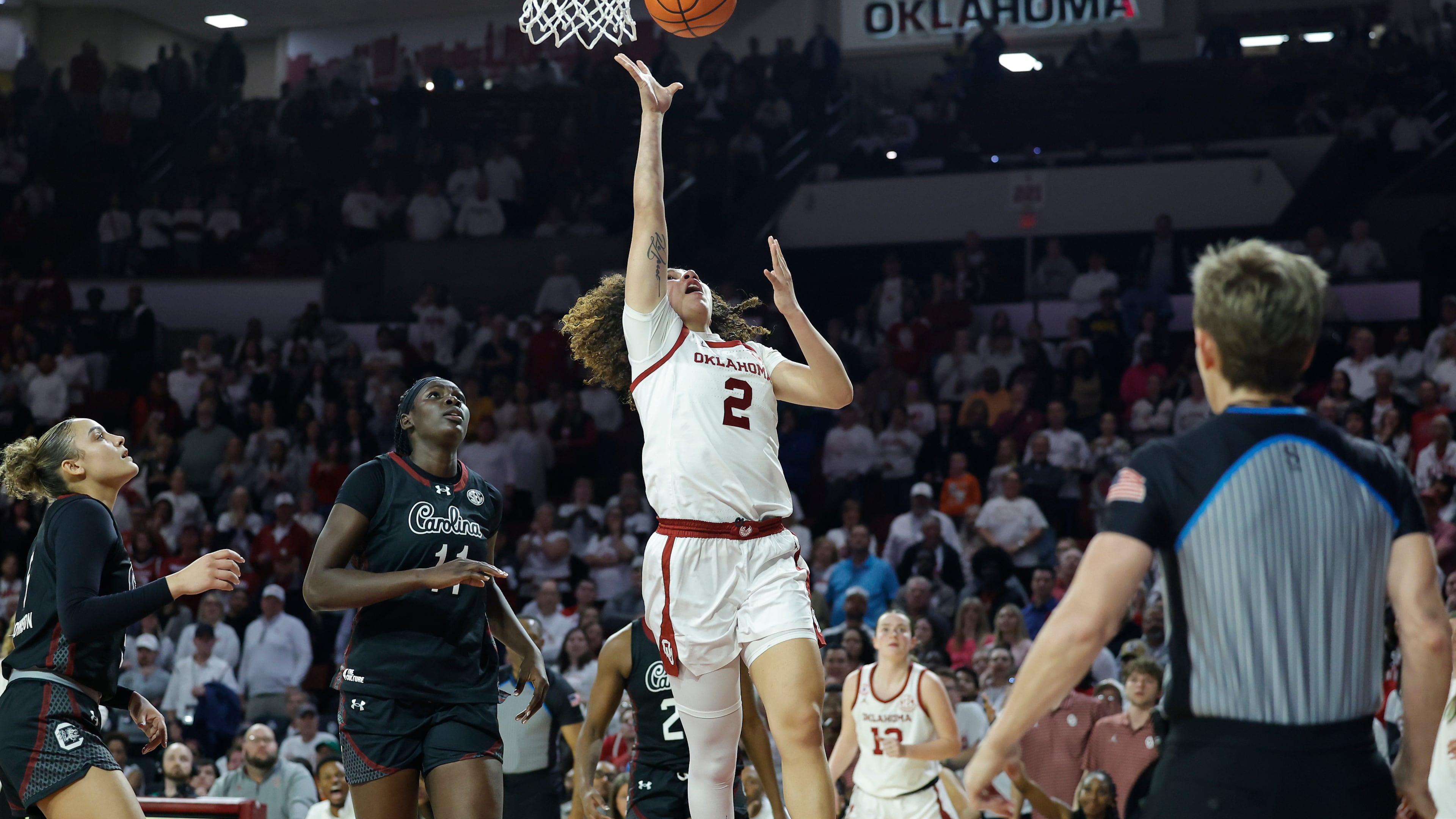 Oklahoma guard Aaliyah Chavez (2) goes up for a basket beside South Carolina center Madina Okot (11) during overtime of a NCAA college basketball game Thursday, Jan. 22, 2026 in Norman, Okla. (AP Photo/Alonzo Adams)