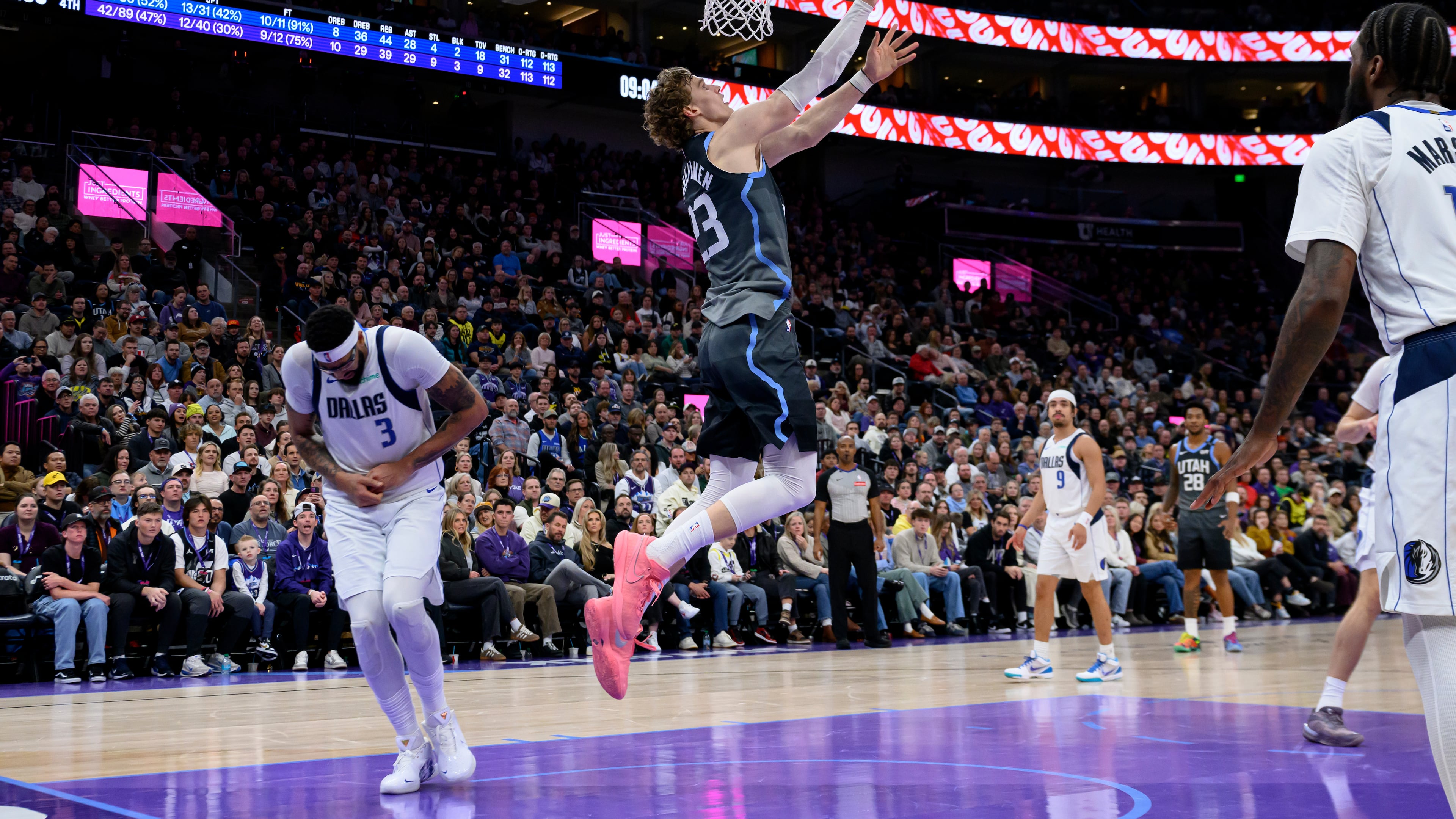 Utah Jazz forward Lauri Markkanen, center, lays the ball to the basket as Dallas Mavericks forward Anthony Davis, left, is injured on the play during the second half of an NBA basketball game against the Dallas Mavericks, Thursday, Jan. 8, 2026, in Salt Lake City. (AP Photo/Tyler Tate)