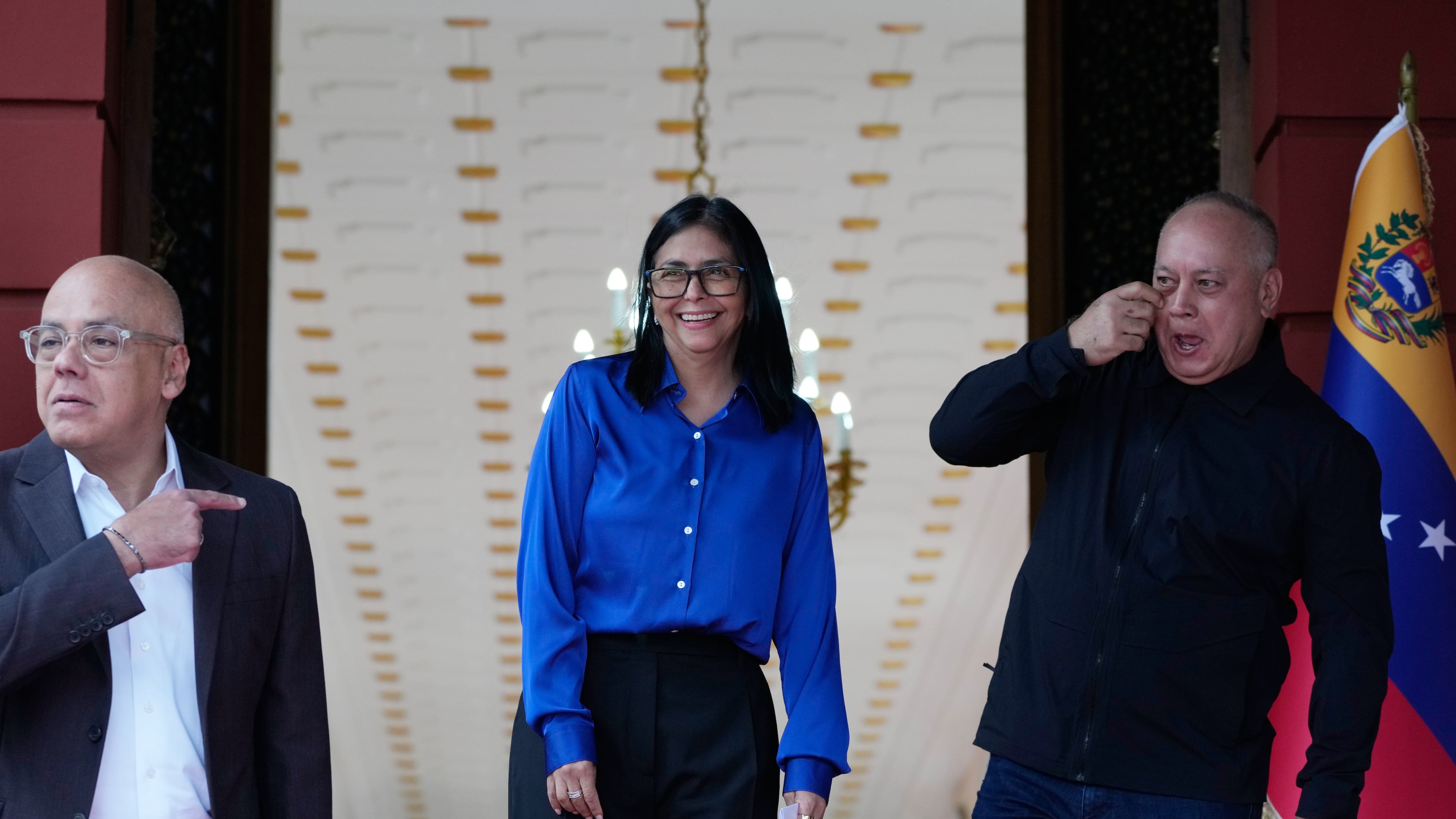 Venezuela's acting President Delcy Rodriguez, center, smiles flanked by Interior Minister Diosdado Cabello, right, and National Assembly President, her brother, Jorge Rodriguez, as they prepare ot make a statement in Caracas, Venezuela, Wednesday, Jan. 14, 2026. (AP Photo/Ariana Cubillos)