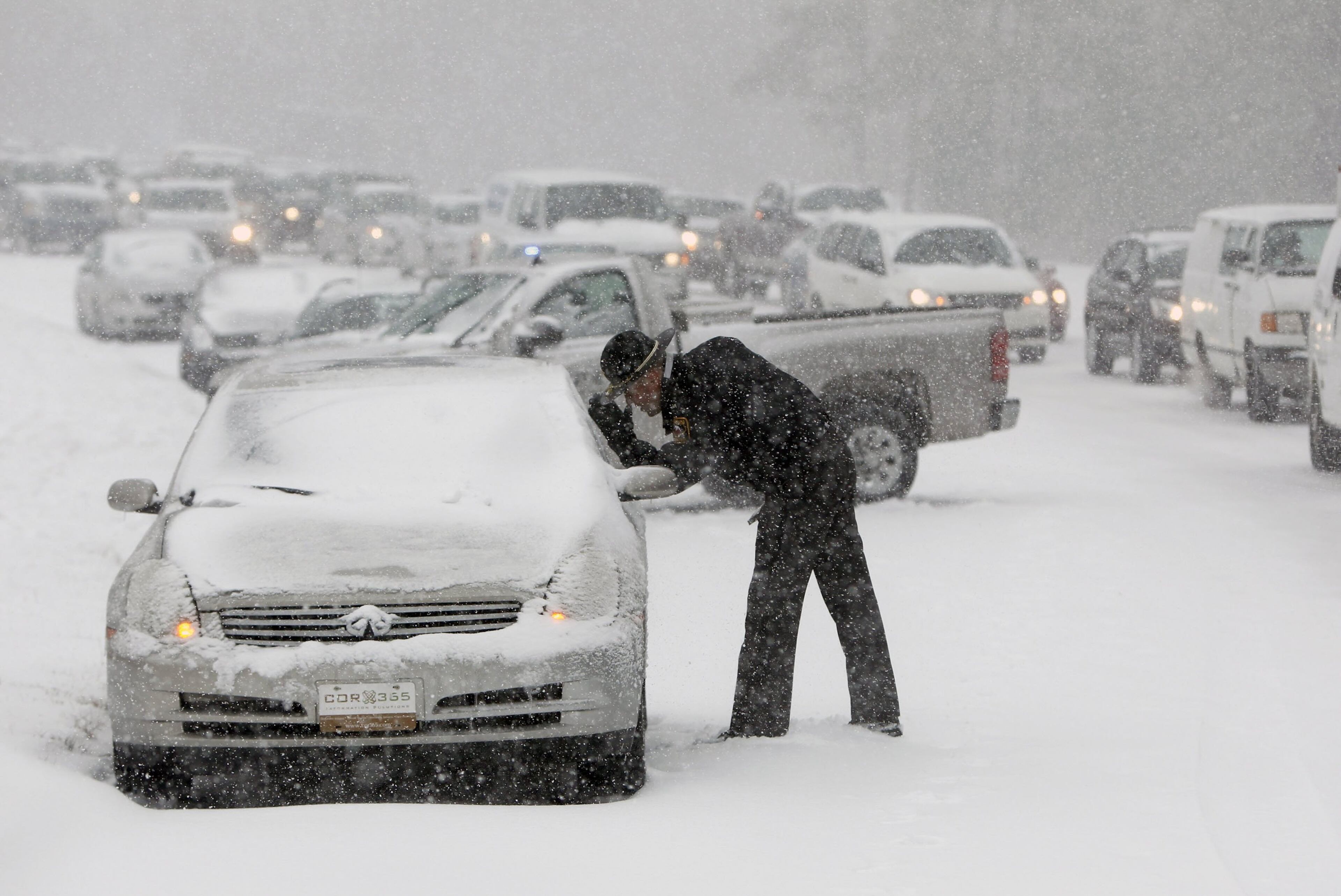 A Highway Patrol officer checks on the safety of a stranded motorist on Hammond Road in Raleigh, N.C., during a winter storm on Wednesday, Feb. 12, 2014. (Travis Long/Raleigh News & Observer/MCT)