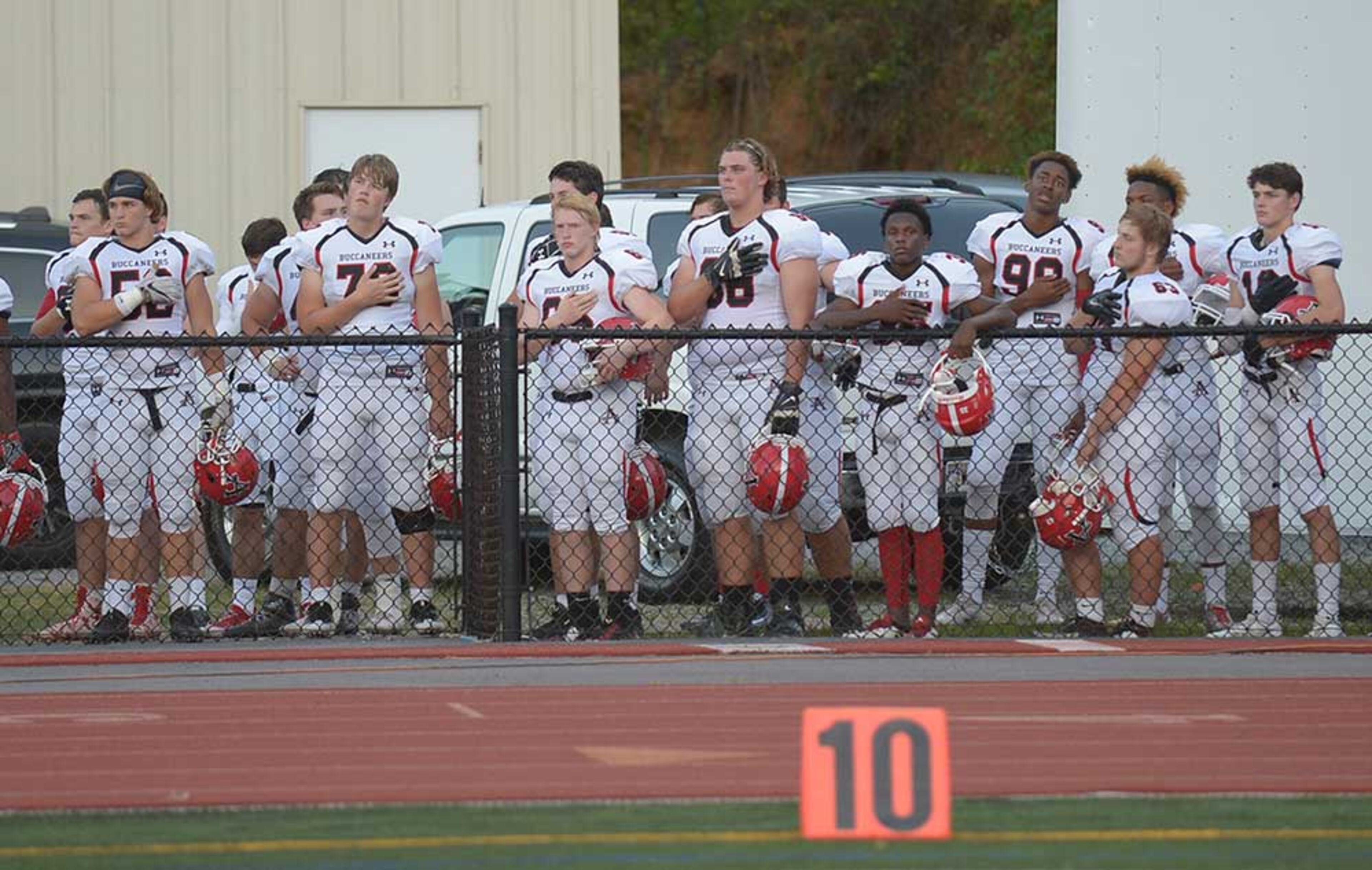 Allatoona players and coaches salute during the national anthem.