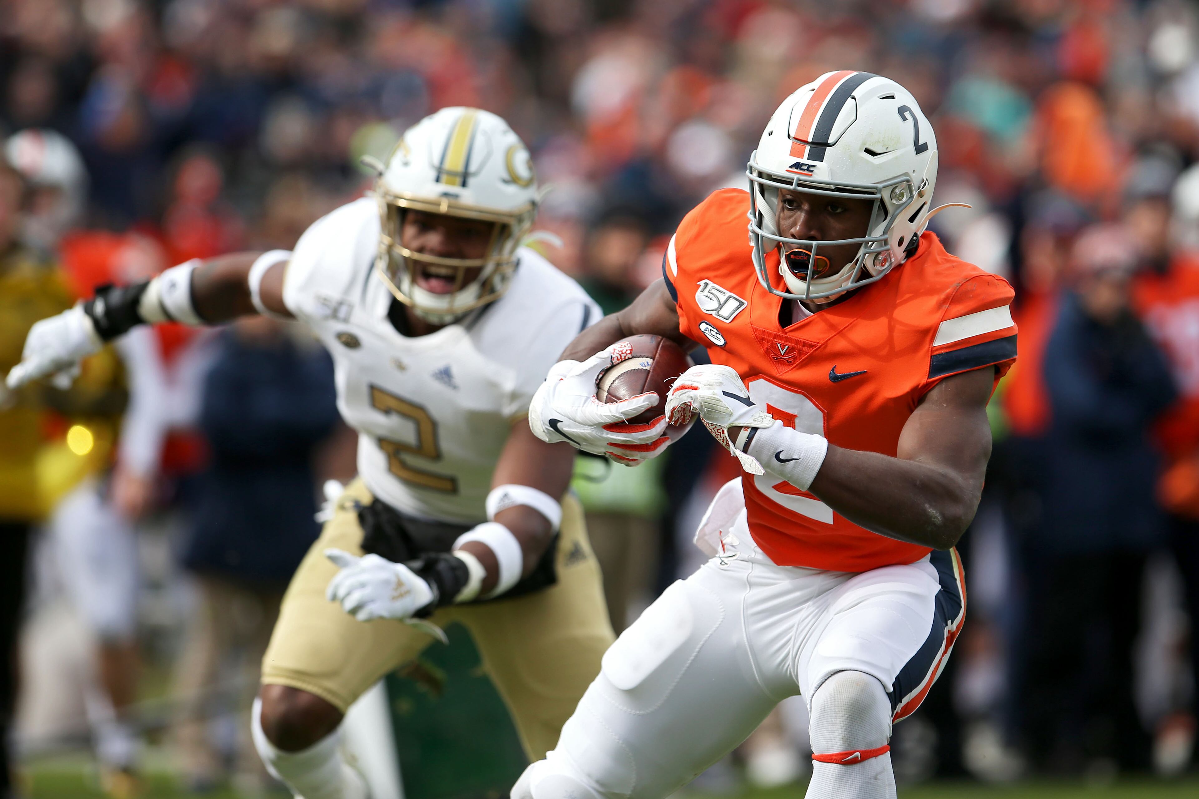 Joe Reed #2 of the Virginia Cavaliers scores a touchdown past Tariq Carpenter #2 of the Georgia Tech Yellow Jackets in the first half during a game at Scott Stadium on November 9, 2019 in Charlottesville, Virginia. (Photo by Ryan M. Kelly/Getty Images)