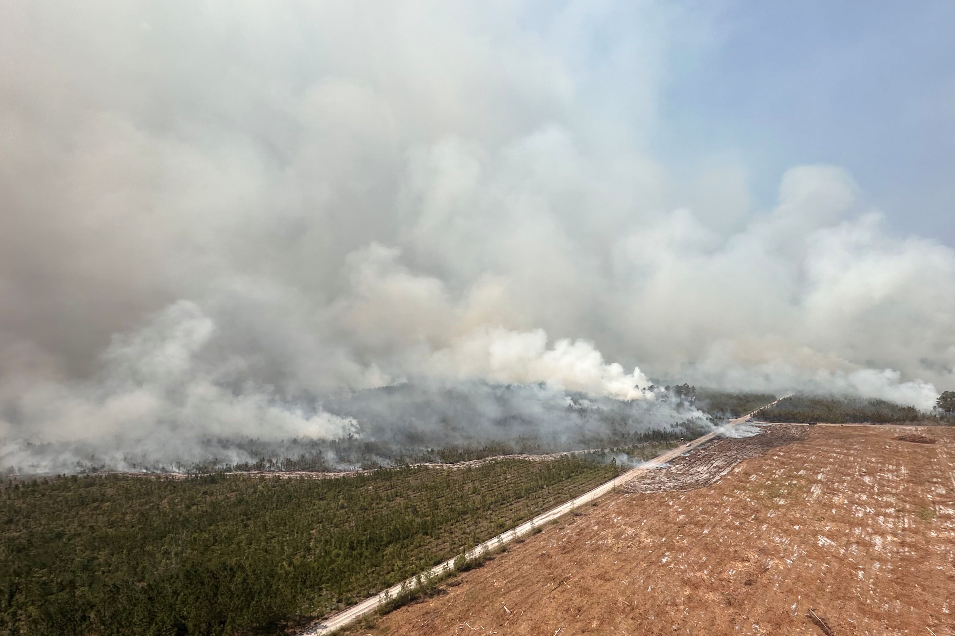 The photo provided by the Office of Gov. Brian Kemp shows smoke produced by a wildfire in Brantley County, Ga., Friday, April 24, 2026. (Office of Gov. Brian Kemp via AP)
