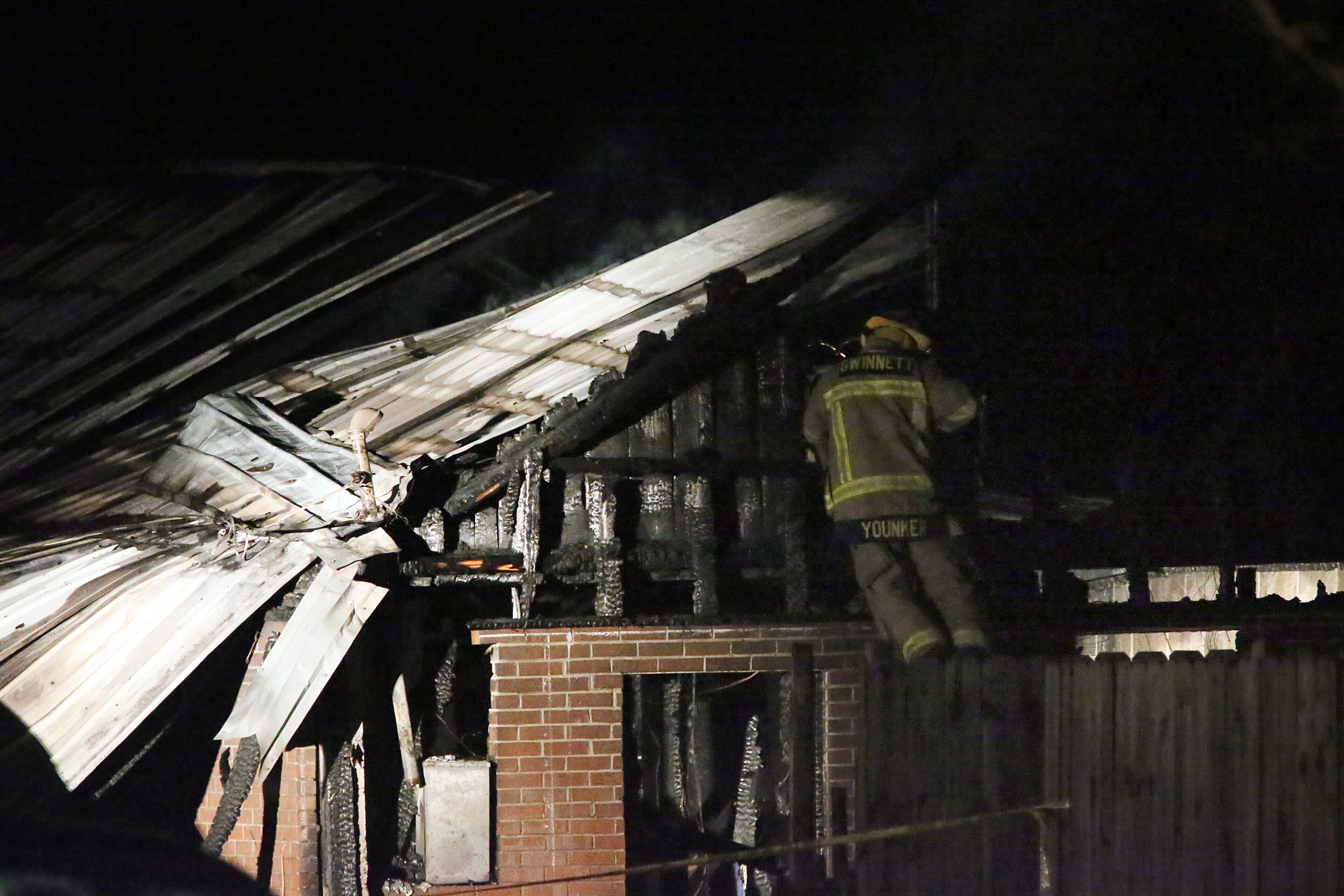 Gwinnett County fire fighters inspect the remains of a home after a fire late Sunday night in Lilburn. One person was found dead. When fire fighters arrived on scene, neighbors and police reported that an occupant was possibly still inside the burning home, Gwinnett County fire Capt. Tommy Rutledge said.