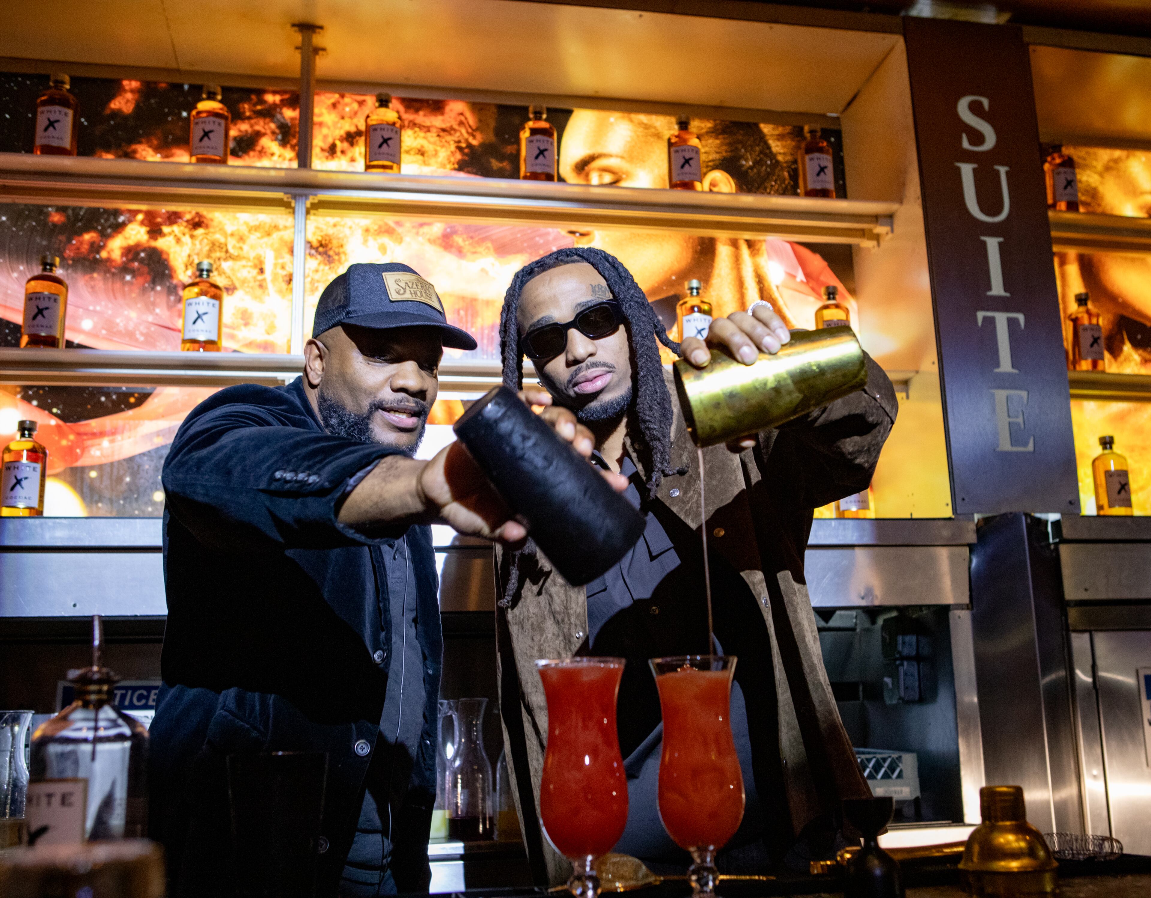 Rapper Quavo, right, partners with White X Cognac and makes a Huncho Hurricane under the direction of mixologist Ben Carrington, left, during a tasting at Suite Lounge on Wednesday, January 24, 2024. (Jenni Girtman for The Atlanta Journal-Constitution)