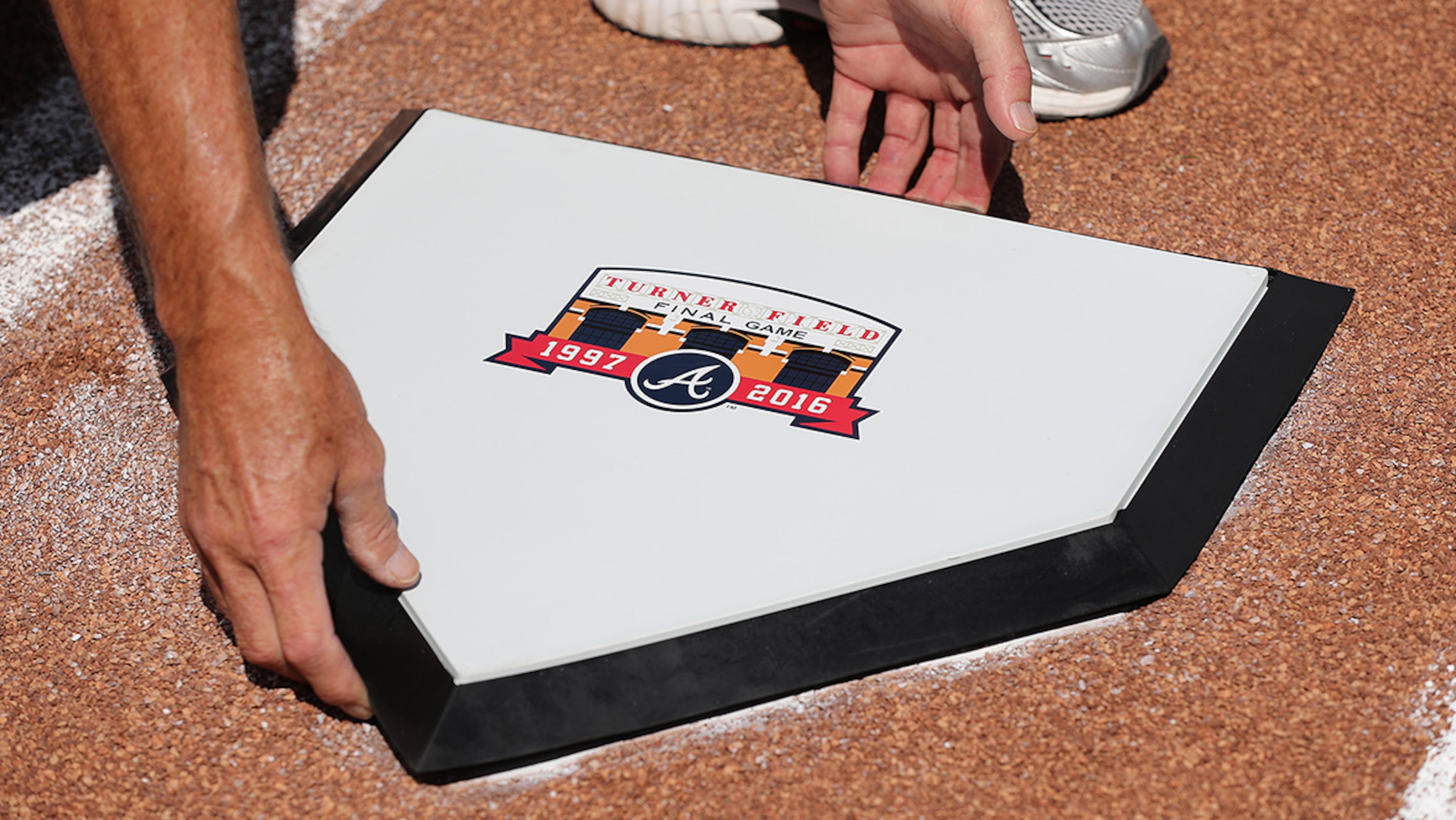 Ground crew member Kim Bode installs the special home plate for the final Braves game at Turner Field on Sunday, Oct. 2, 2016, in Atlanta. The home plate will be moved in a game ending ceremony to the new stadium in Cobb County.
