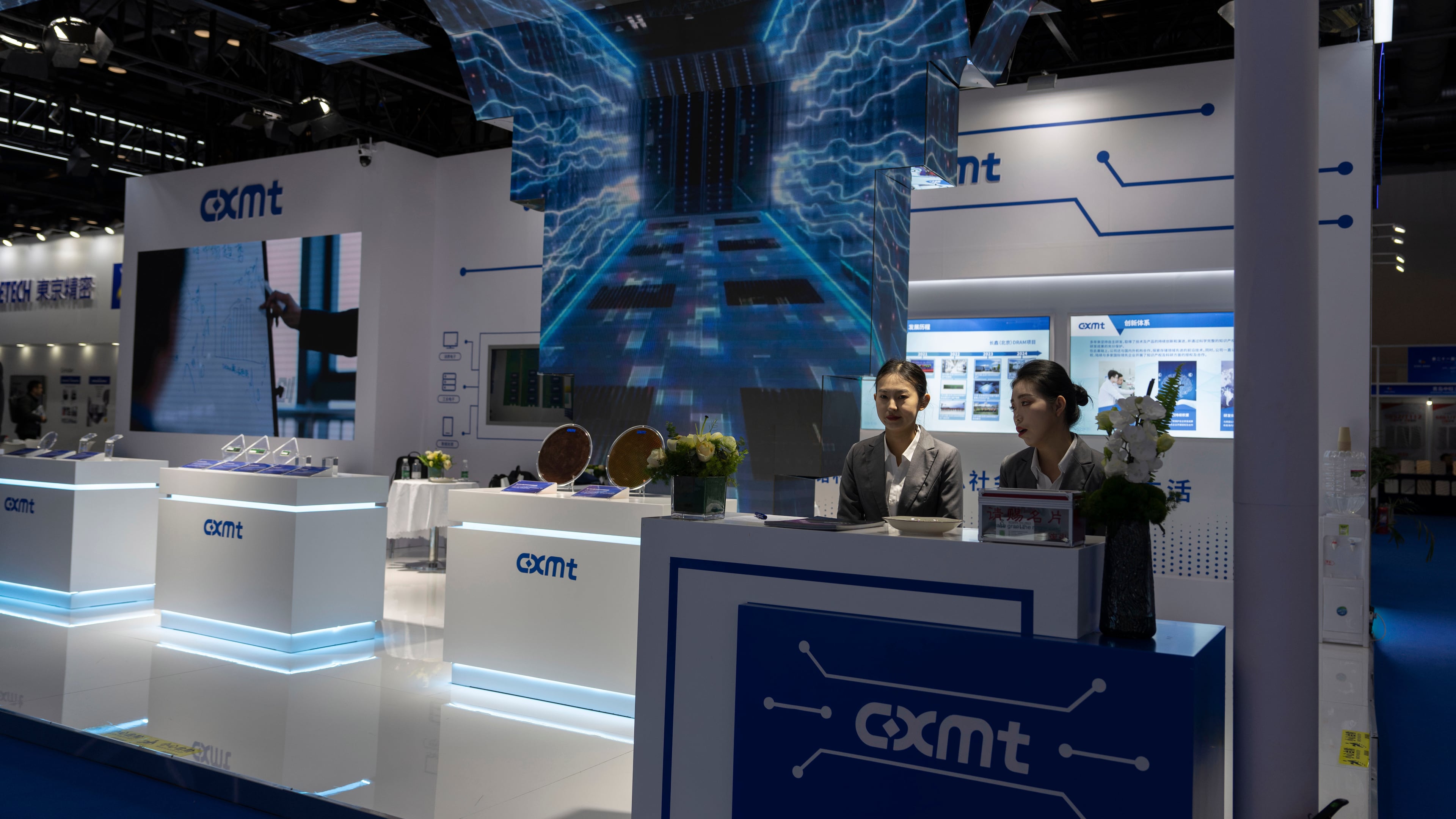 FILE - Workers at the booth for Chinese DRAM producer ChangXin Memory Technologies, also known as CXMT, wait for visitors at the 21st China International Semiconductor Expo in Beijing, Nov. 20, 2024. (AP Photo/Ng Han Guan, File)