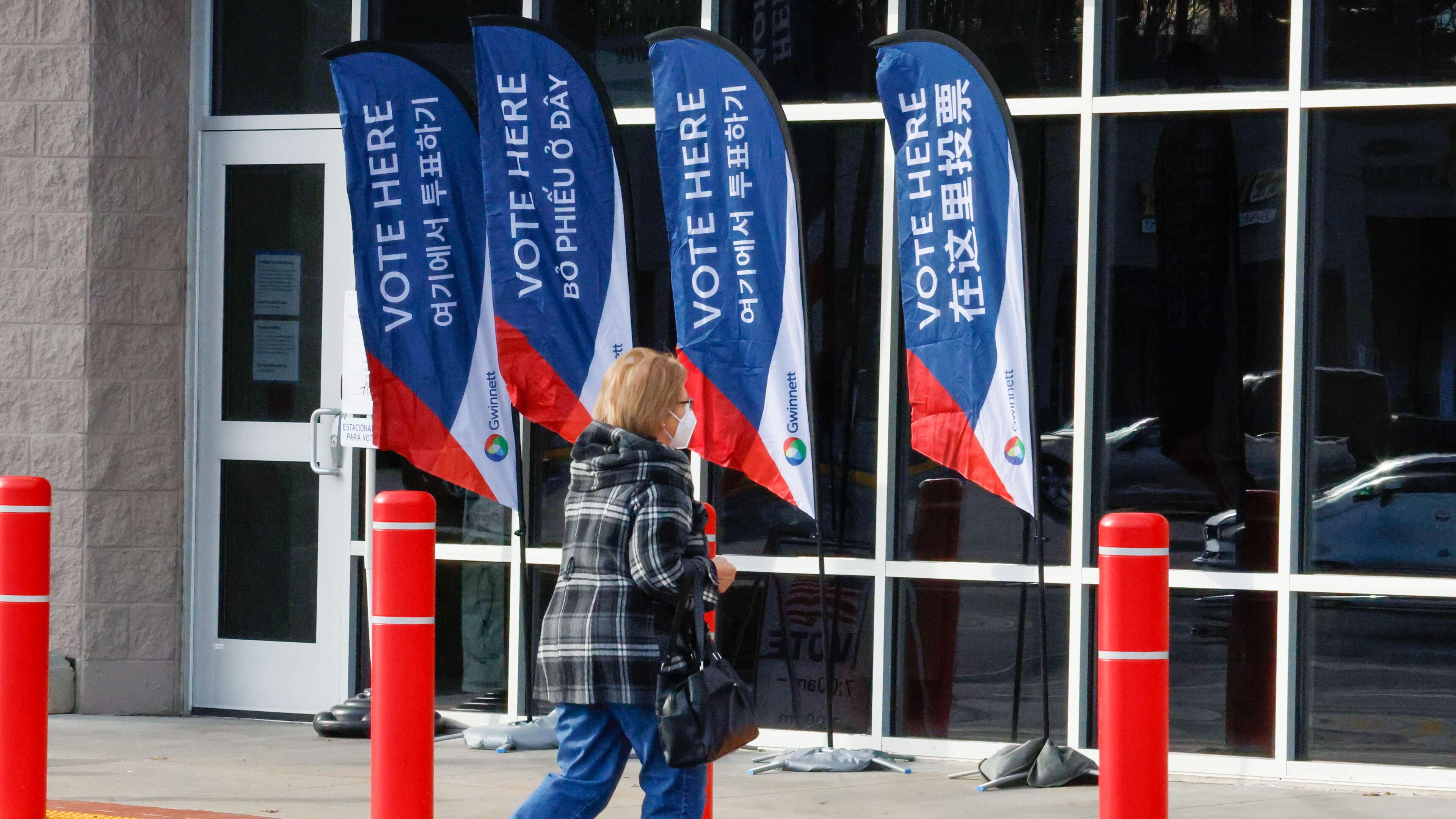 A person walks towards the Gwinnett County Voter and Registration Elections during the first day of early voting for the Georgia presidential primary on Monday, Feb 19, 2024. (Miguel Martinez / miguel.martinezjimenez@ajc.com)