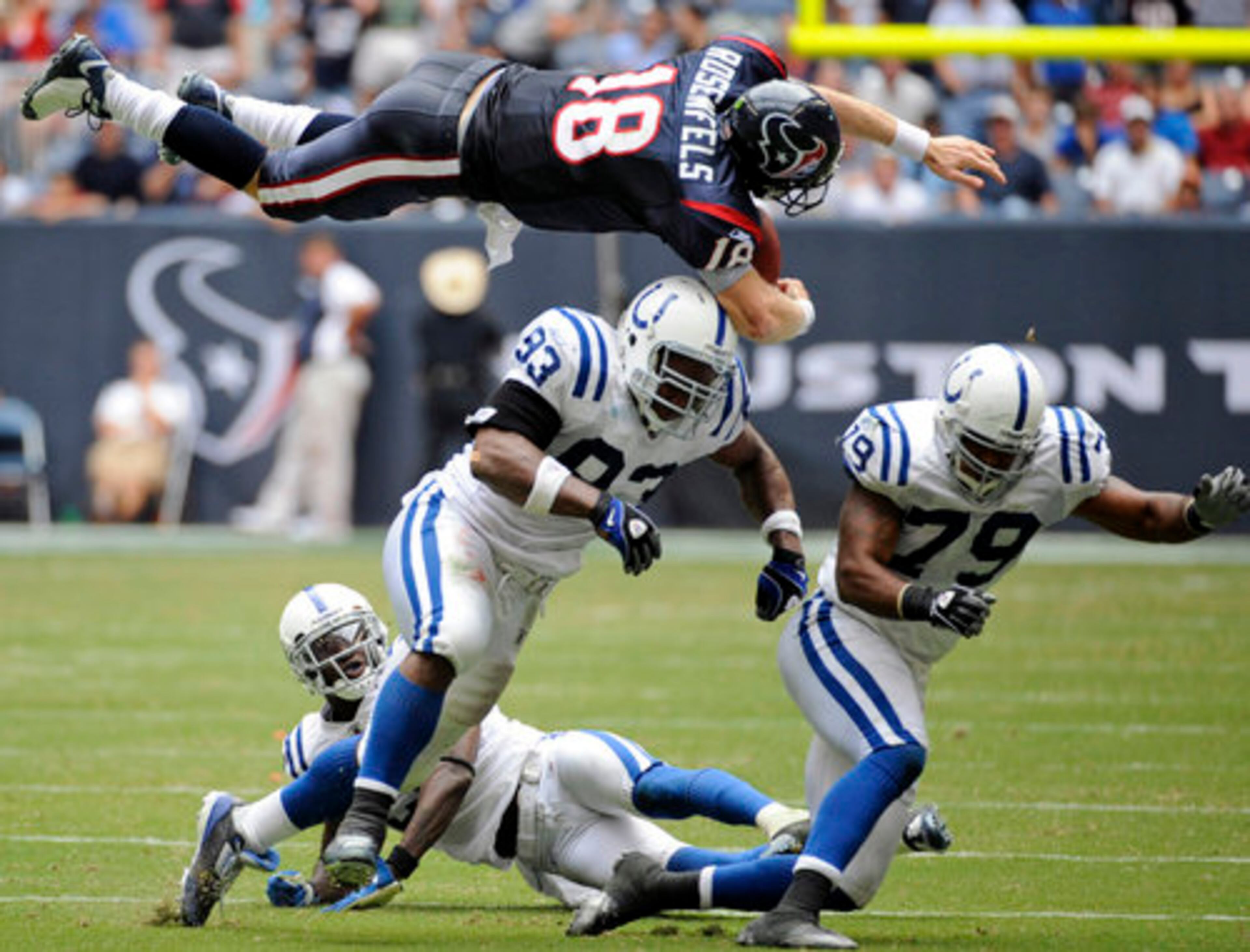 Texans' quarterback Sage Rosenfels (18) flies over Indianapolis Colts' defensive end Dwight Freeney (93) after being hit by Raheem Brock (79) in Houston on Sunday. Rosenfels fumbled the ball and the Colts returned the fumble for a touchdown.
