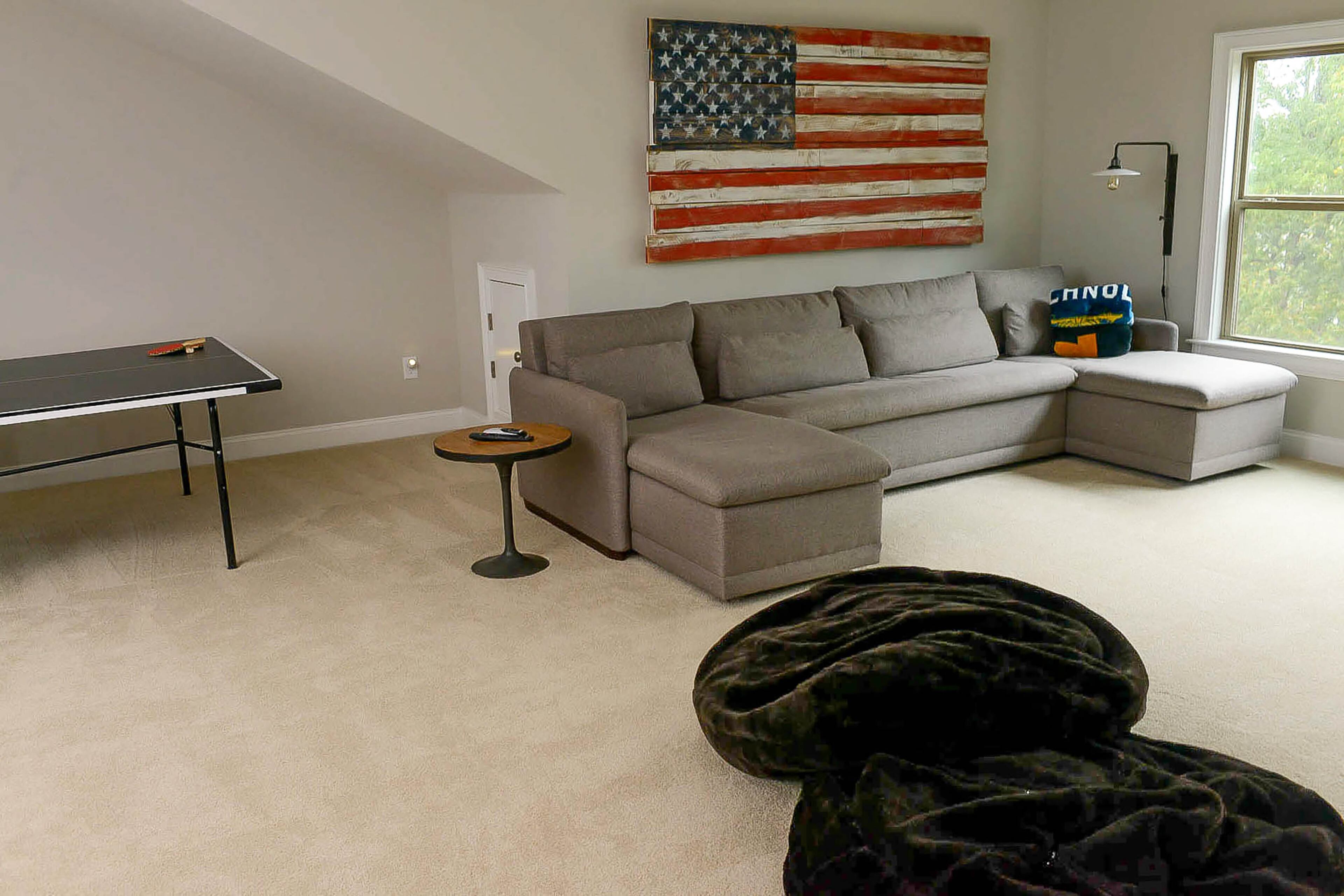 The upstairs loft is a hangout space for 17-year-old Jake and his friends. The original wood artwork is by Emily Harris, and the custom sectional (with stain-resistant fabric) is from Laura Walker Ltd.
