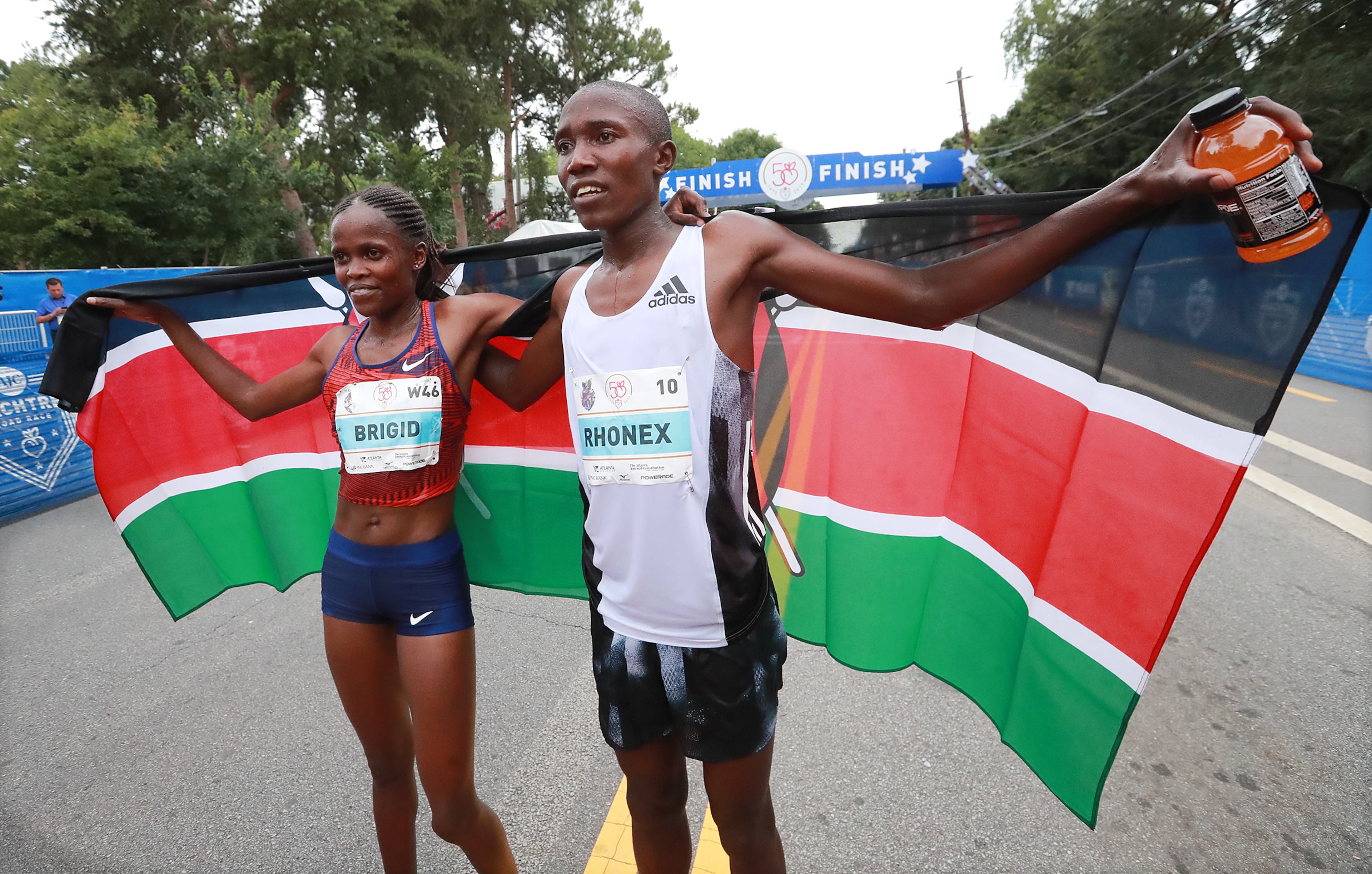 Rhonex Kipruto and Brigid Kosgei celebrate winning the 50th AJC Peachtree Road Race on Thursday, July 4, 2019, in Atlanta. Curtis Compton/ccompton@ajc.com