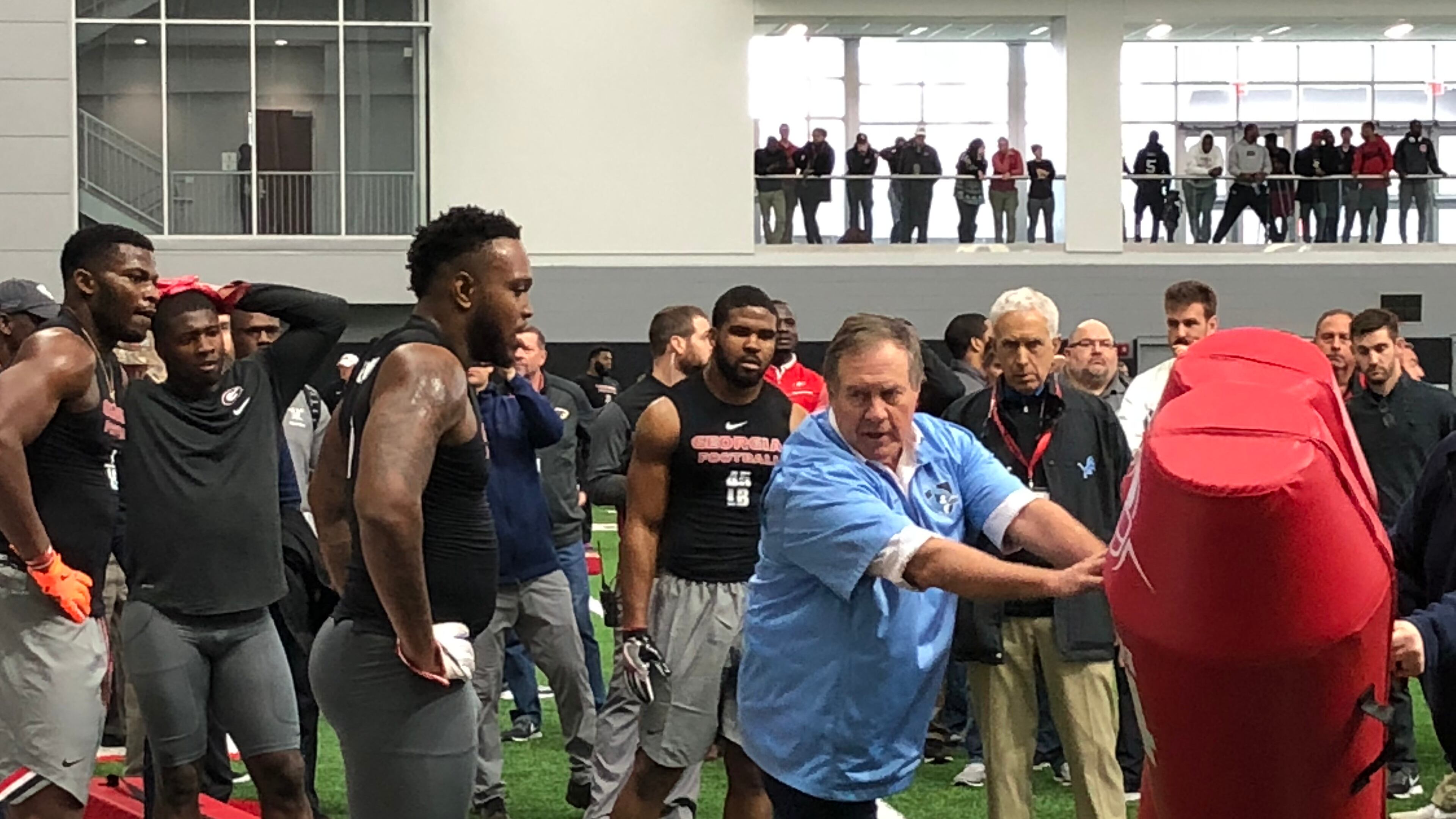 New England coach Bill Belichick instructs former Georgia linebackers Davin Bellamy (center), Lorenzo Carter (far left) and Reggie Carter (rear) on how to run a drill at the Bulldogs’ Pro Day Wednesday in Georgia’s indoor practice facility in Athens.