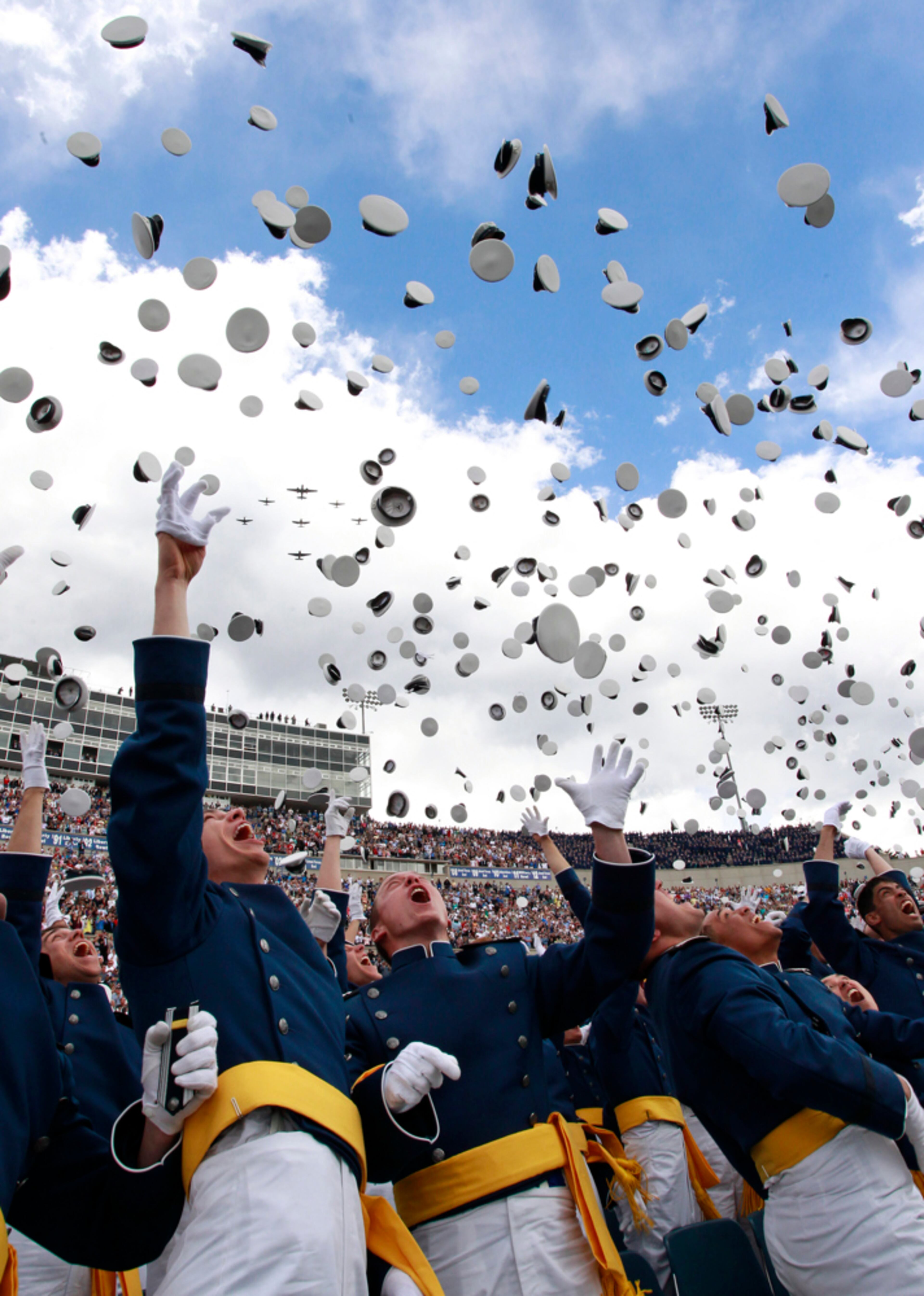 "OFF WE GO..."--Graduating Air Force 2nd Lieutenants throw their caps into the air at the completion of the commencement ceremony for the class of 2013, at the U.S. Air Force Academy, in Colorado, Wednesday May 29, 2013. In the background, a group of WWII warplanes do a flyover.(AP Photo/Brennan Linsley)